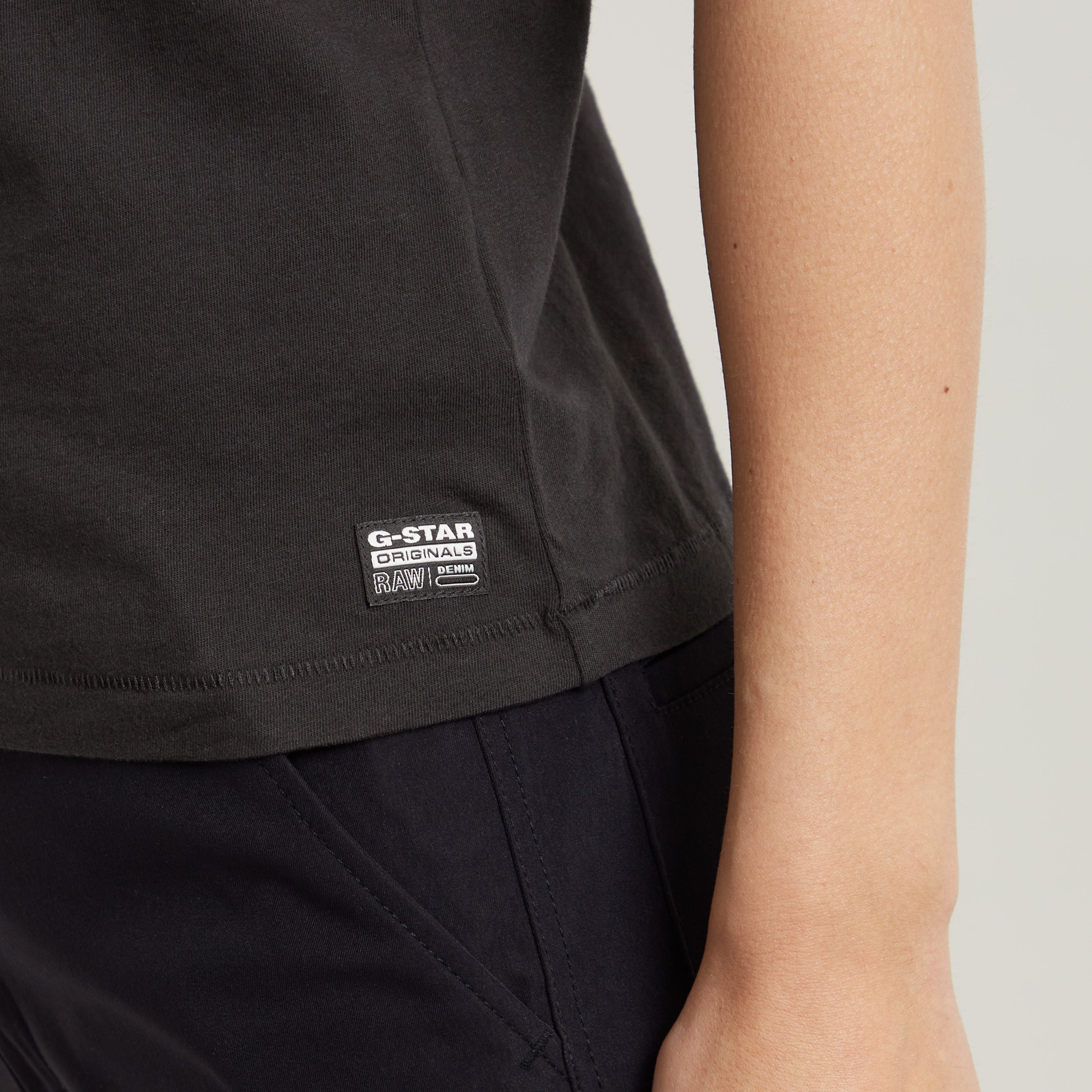 Faux embroidered logo top close-up showing G-Star Originals label on dark black fabric.