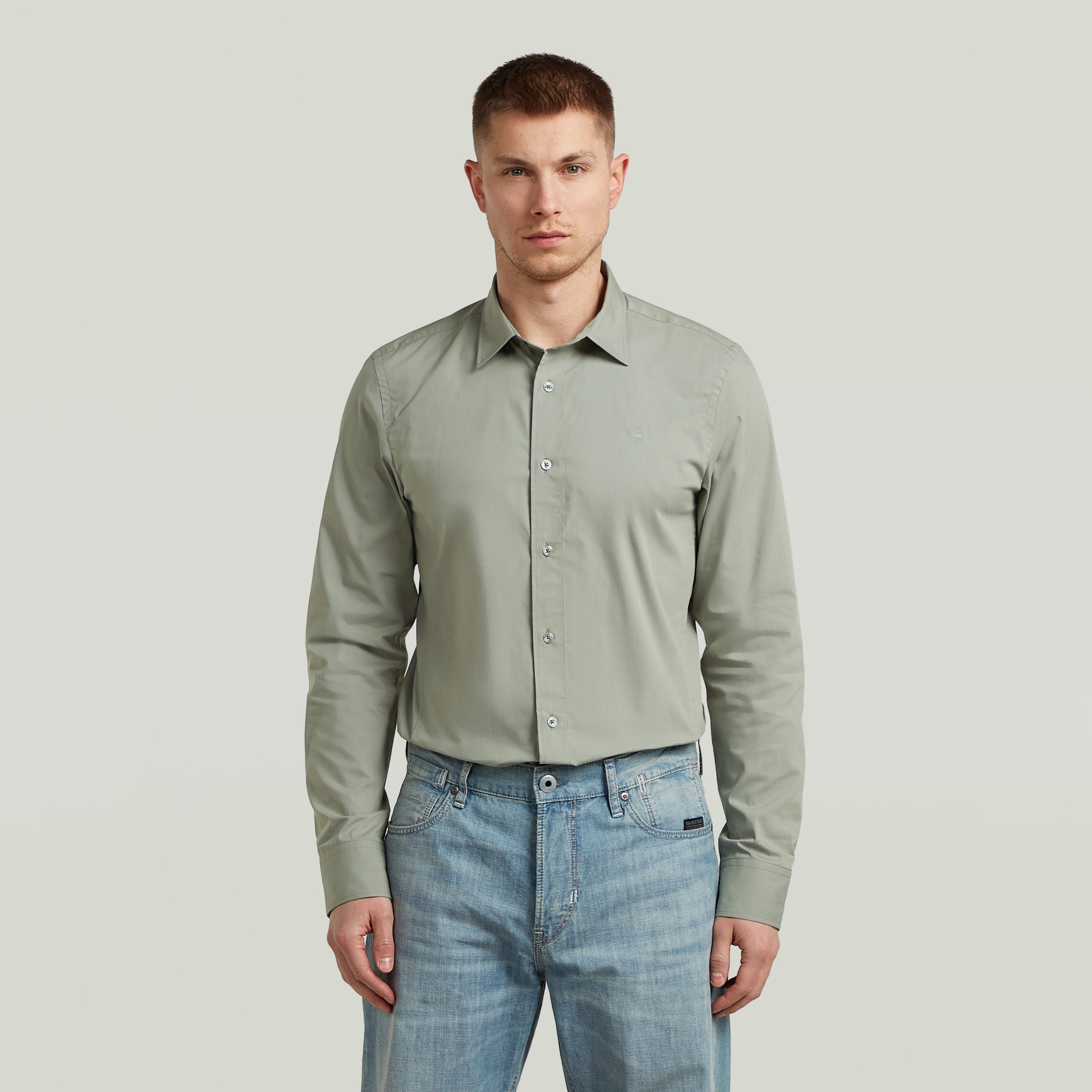 Hombre con camisa Uniform Slim de manga larga, color verde, una slim fit uniform shirt de algodón y poliéster.