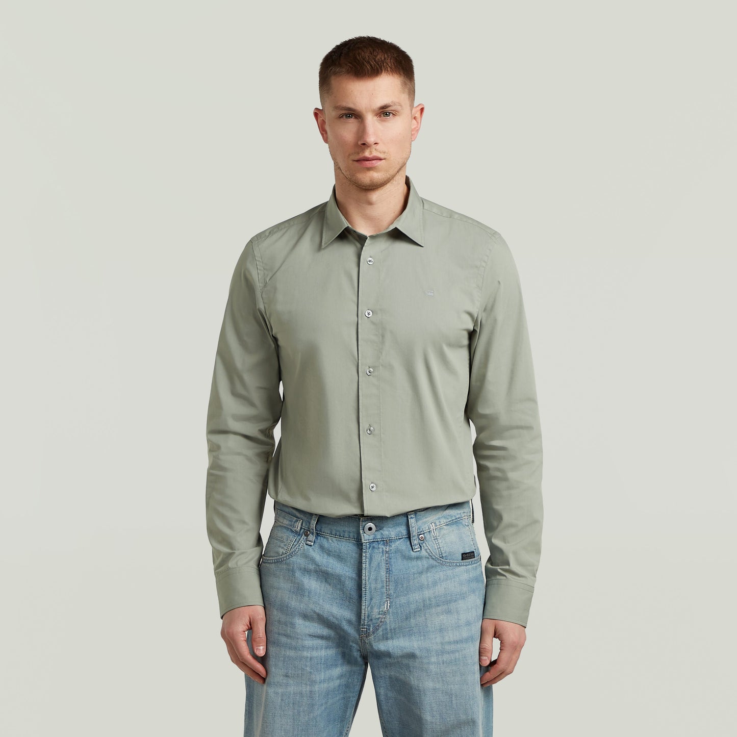 Hombre con camisa Uniform Slim de manga larga, color verde, una slim fit uniform shirt de algodón y poliéster.