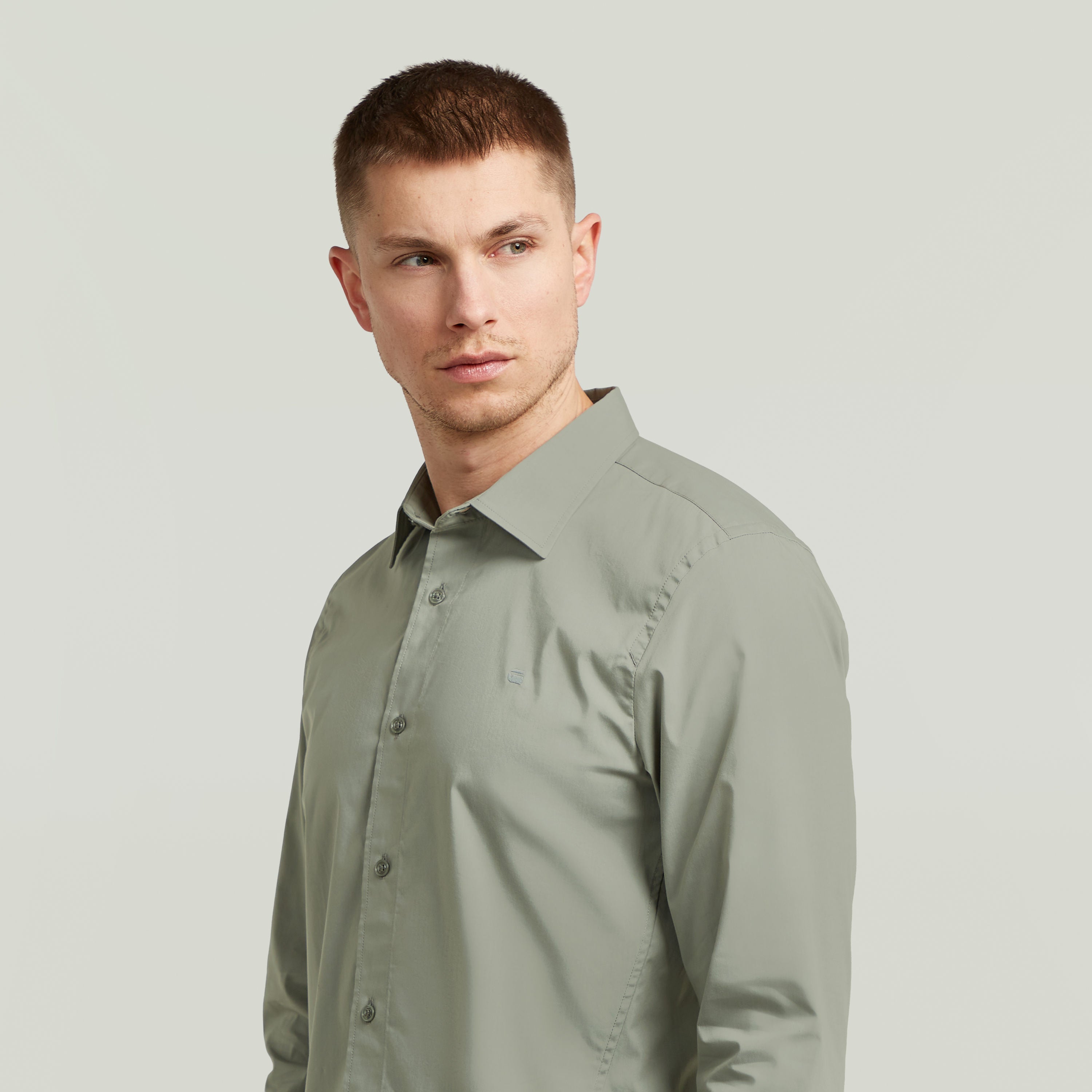 Hombre usando una camisa uniform slim fit uniform shirt de color verde con corte ajustado y cuello de camisa.