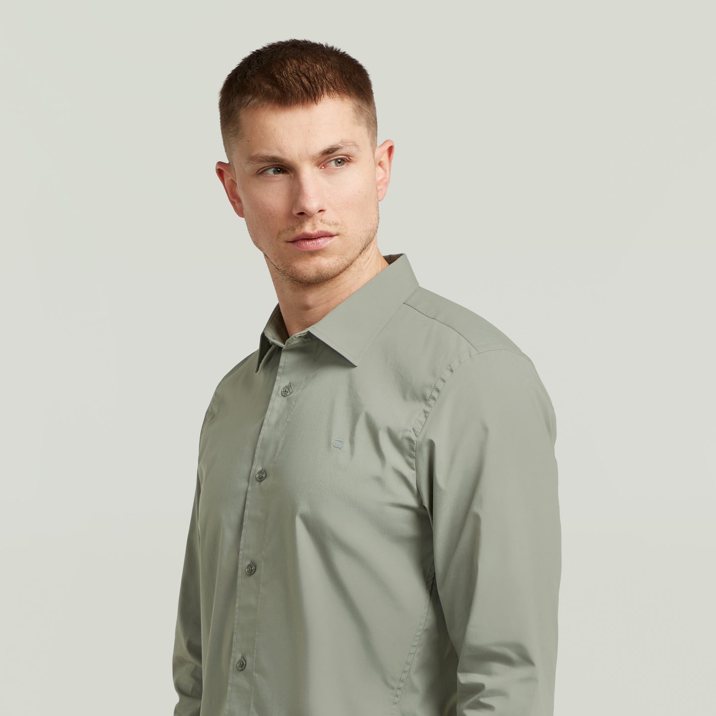 Hombre usando una camisa uniform slim fit uniform shirt de color verde con corte ajustado y cuello de camisa.