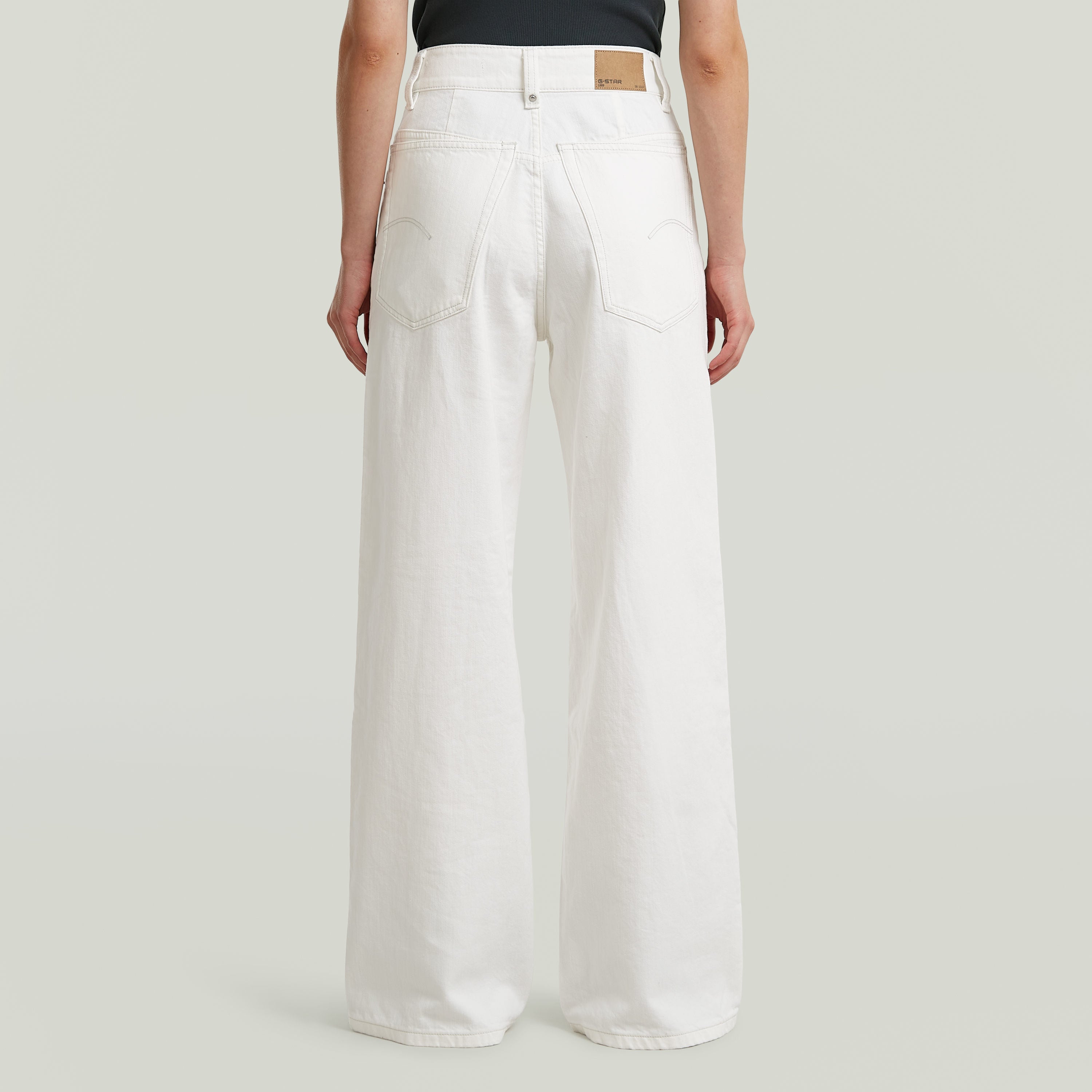 White high loose skater jeans showcasing back pockets and drop-crotch design for comfort.