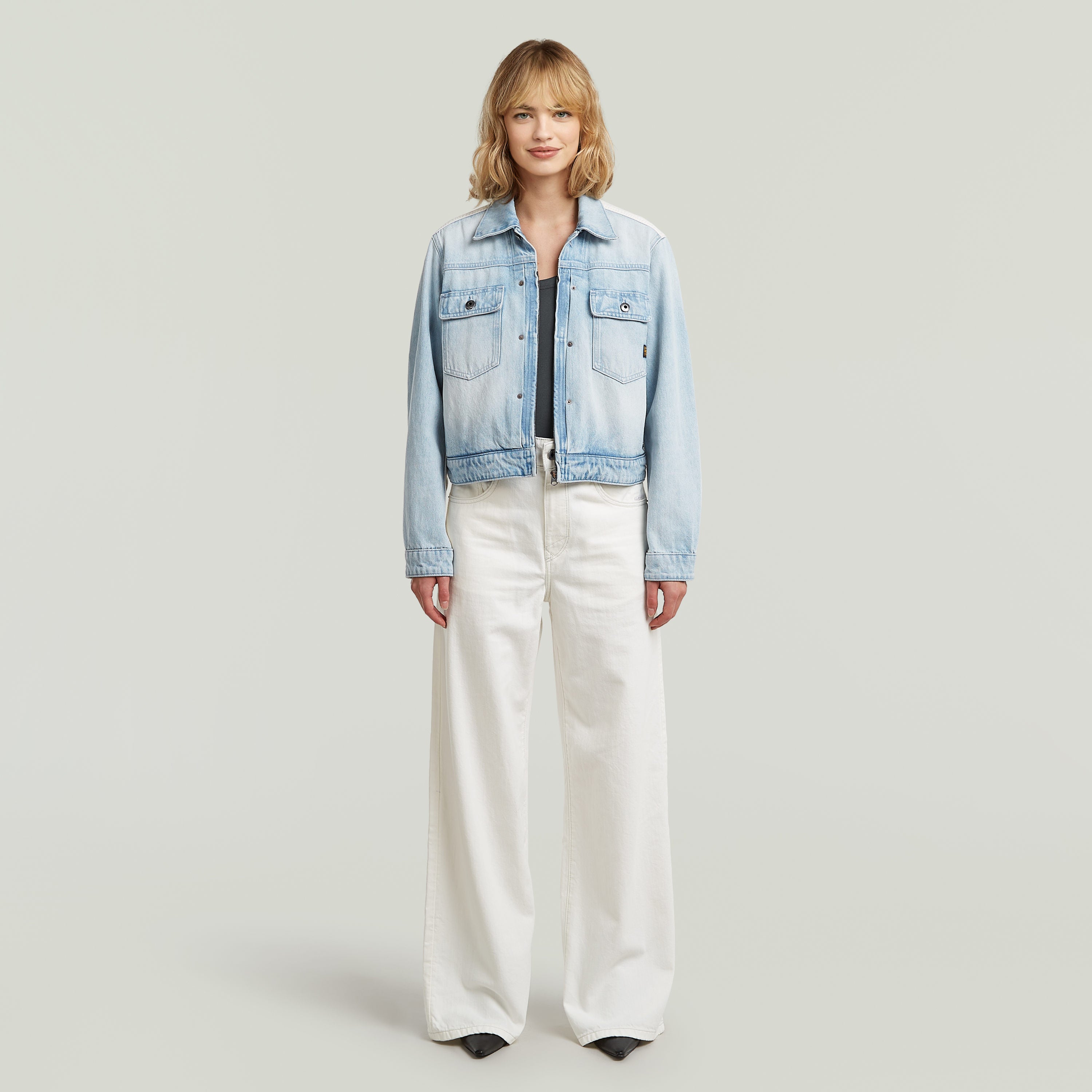 Model wearing high loose skater jeans with a cropped denim jacket, showcasing street style fashion.