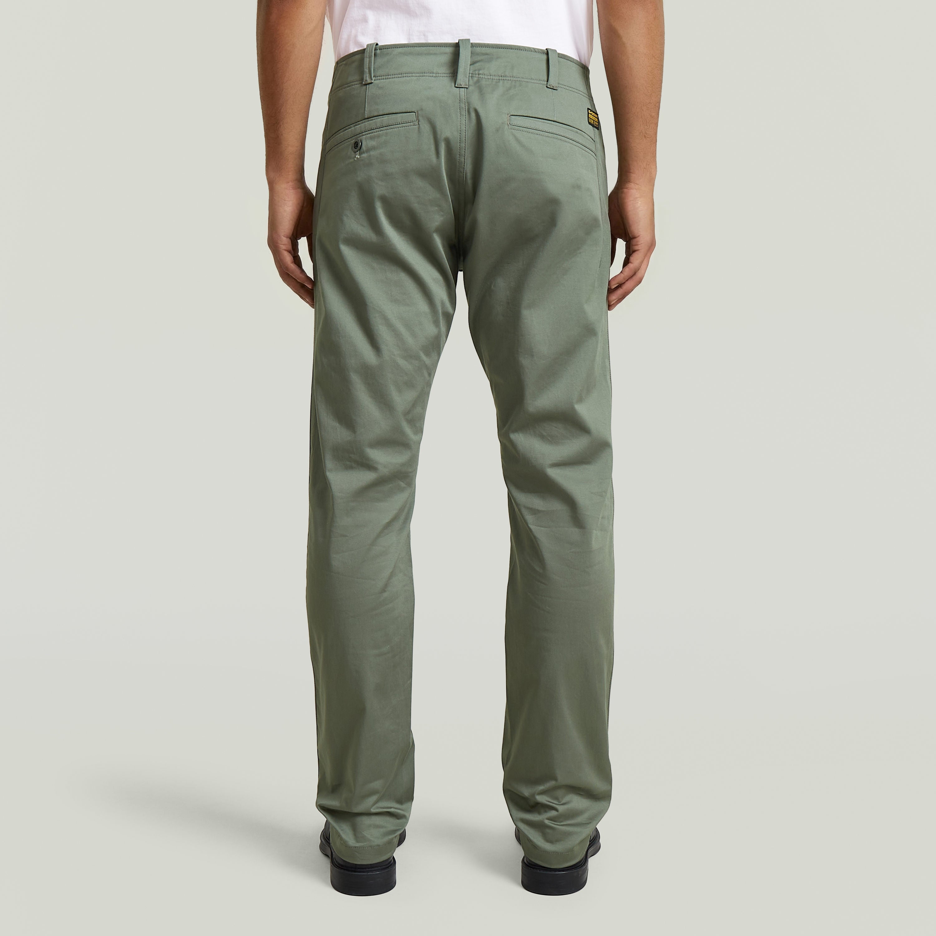 Pantalones chinos rectos Mosa, vista trasera, tejido elástico en color verde, diseño con cinco bolsillos.