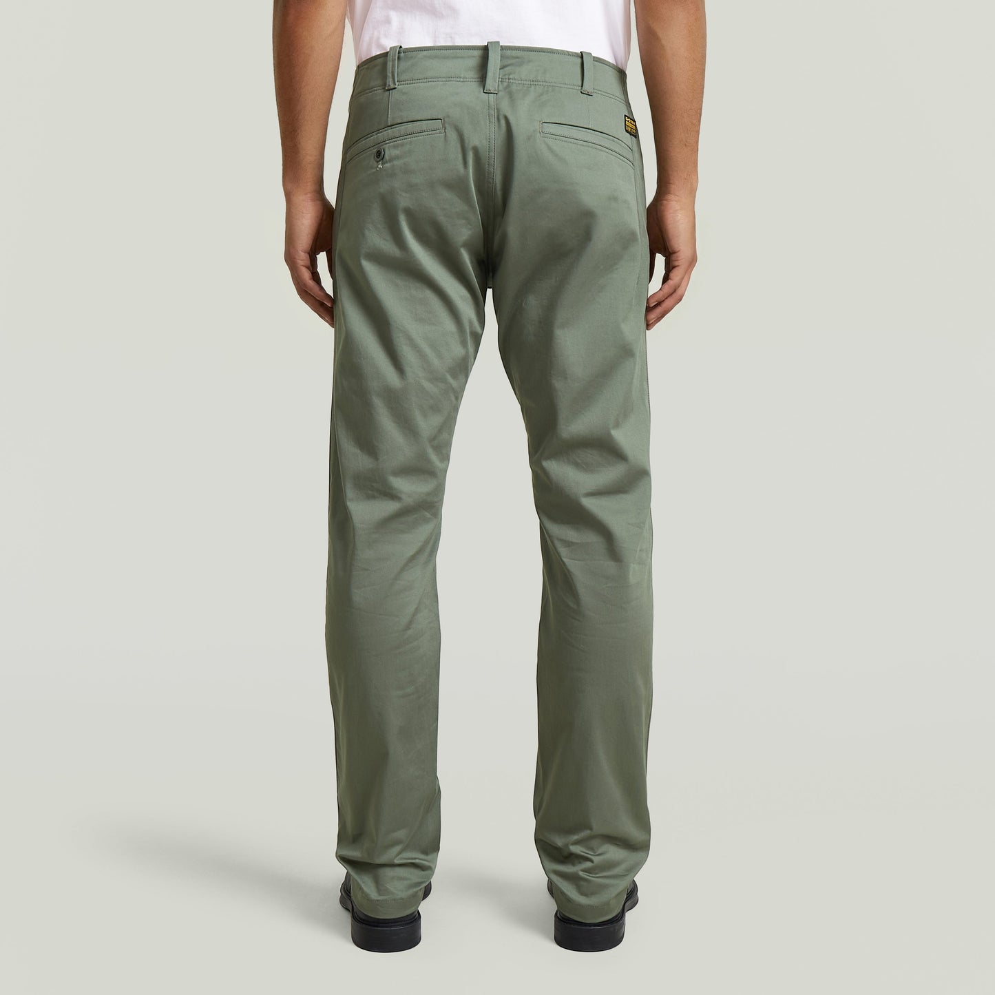 Pantalones chinos rectos Mosa, vista trasera, tejido elástico en color verde, diseño con cinco bolsillos.