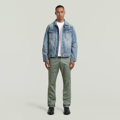 Hombre vistiendo pantalones chinos rectos Mosa con chaqueta de mezclilla y camiseta blanca.