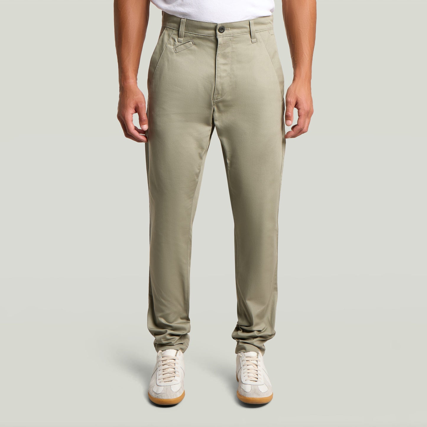 Modelo usando pantalones Bronson 3.0 slim fit chino en color verde claro con camiseta blanca y zapatillas.