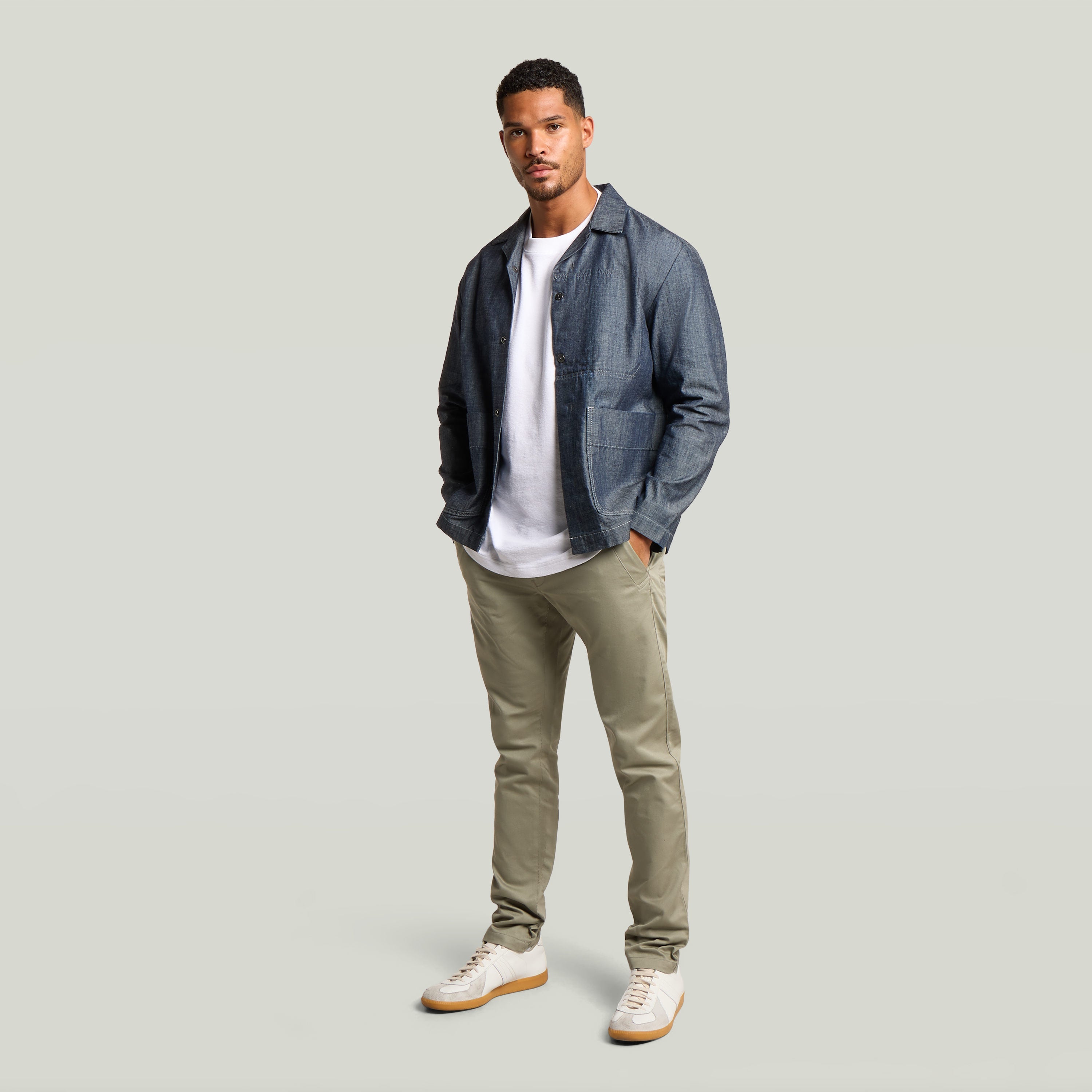 Modelo masculino usando Pantalones Bronson 3.0 Slim Chino con chaqueta y camiseta blanca, ideales para estilo casual.