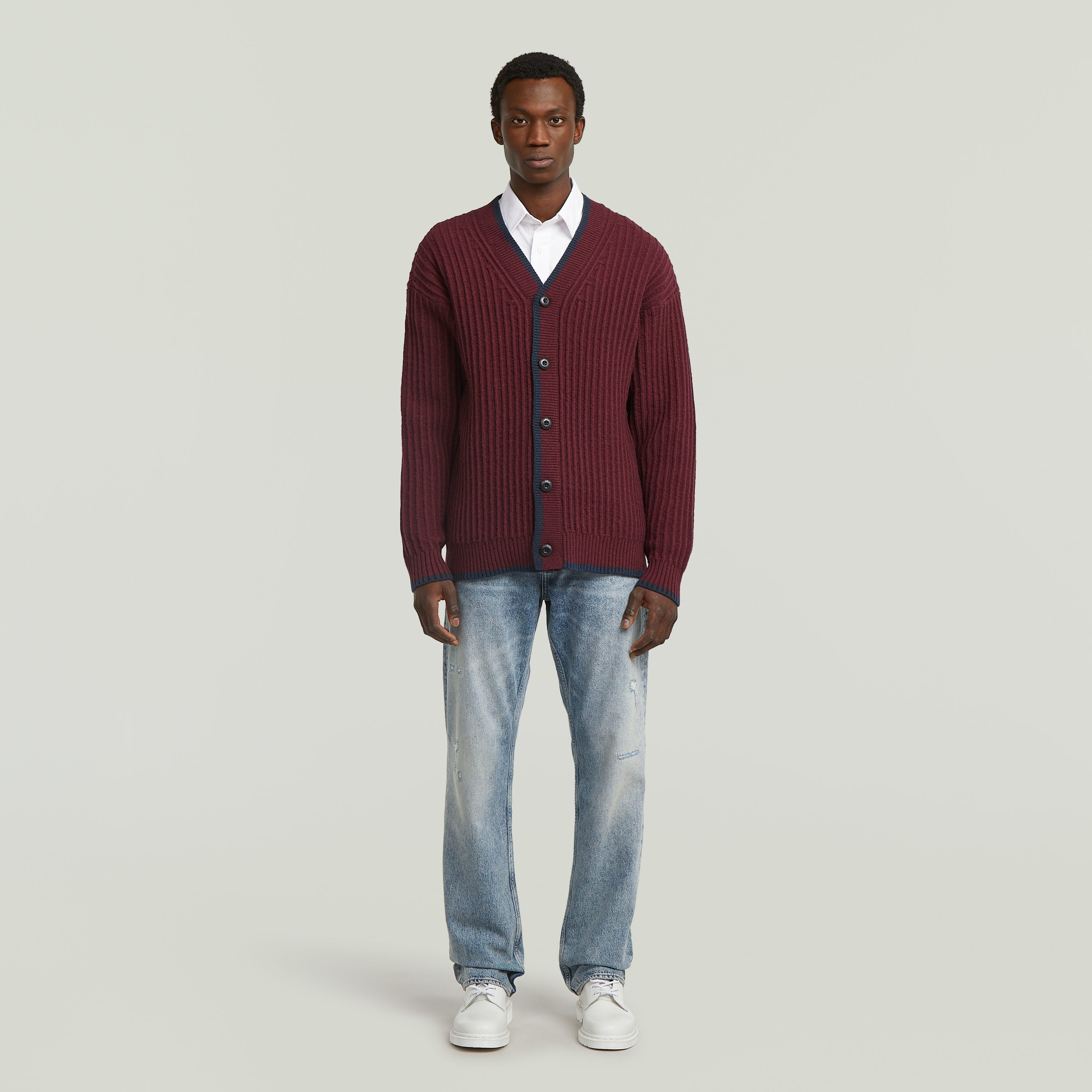 men's V-neck cardigan knit worn by a model in burgundy color with a casual outfit.