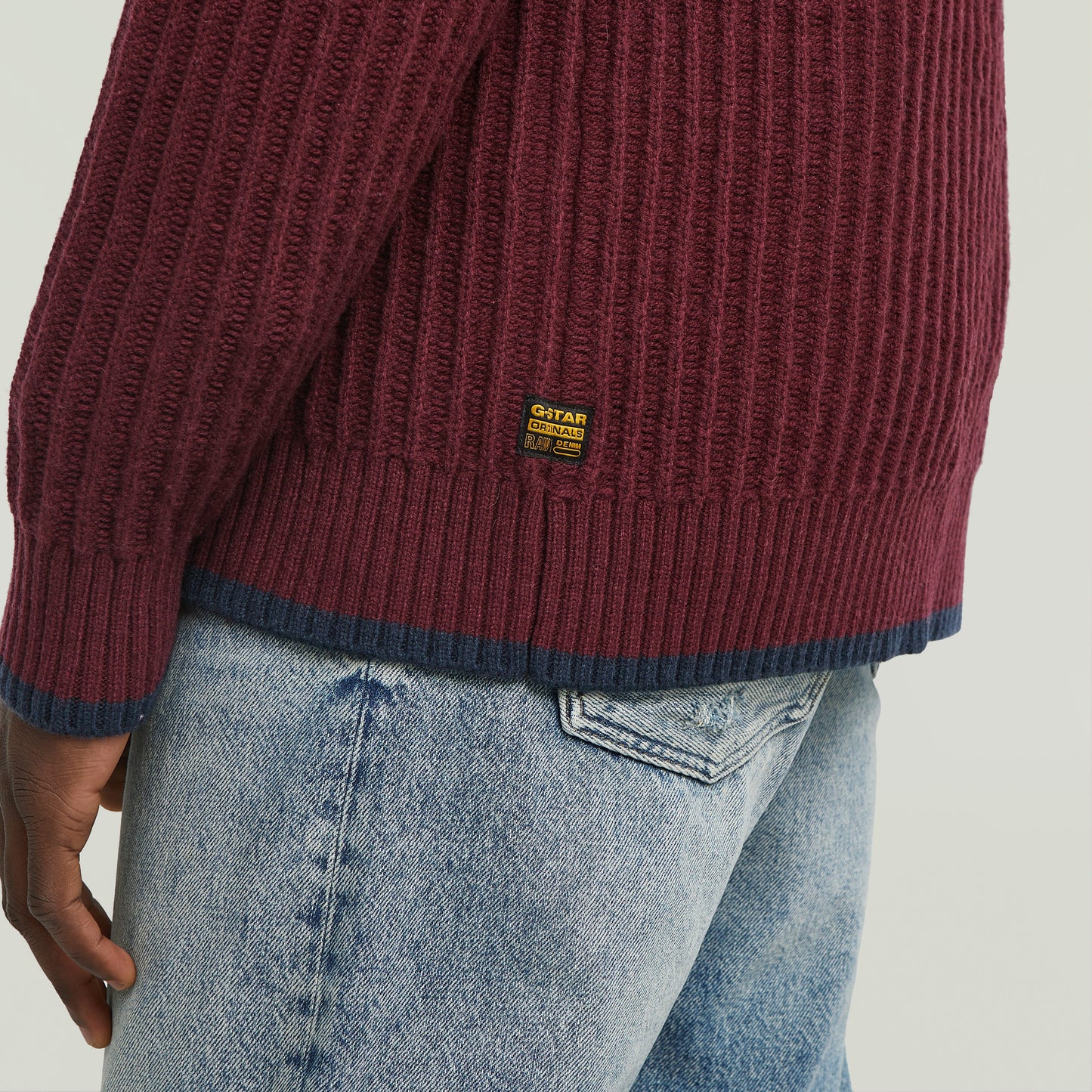 men's V-neck cardigan knit showing ribbed texture and label detail on the back.