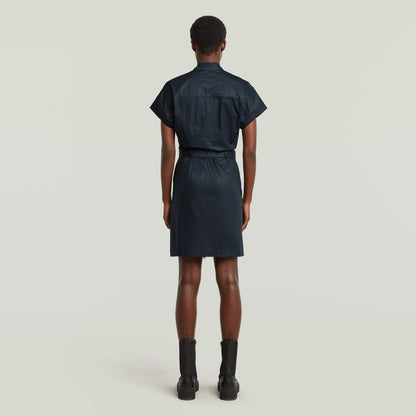 Mujer de espaldas luciendo vestido belted de algodón orgánico color azul oscuro.