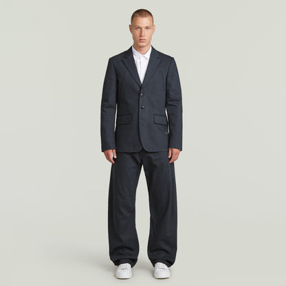 A-Line tailored denim blazer worn by a man, featuring structured silhouette and classic button closure in dark blue.
