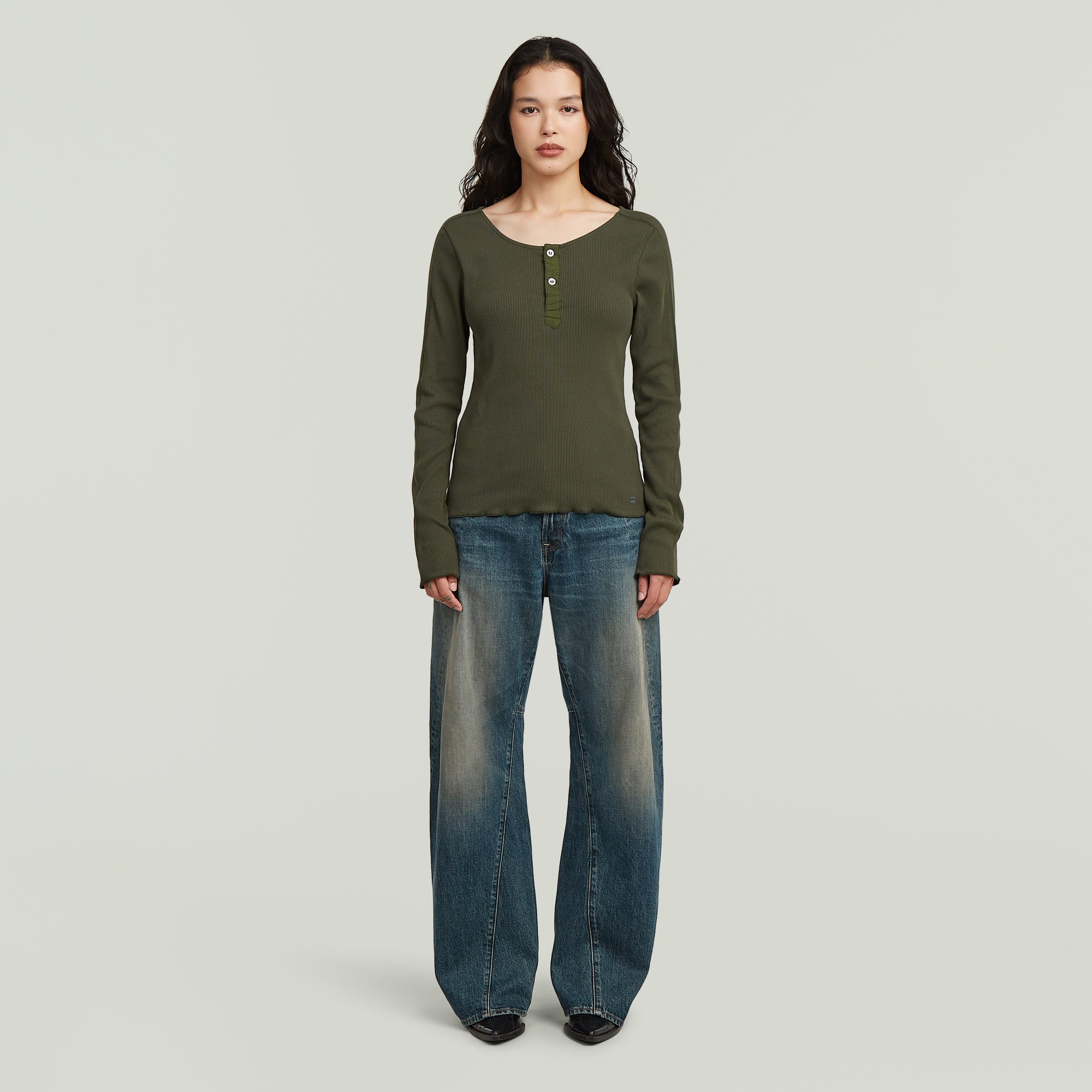 Mujer usando jeans Contor 3D wide fit en un ambiente neutral, mostrando su corte holgado y diseño moderno.