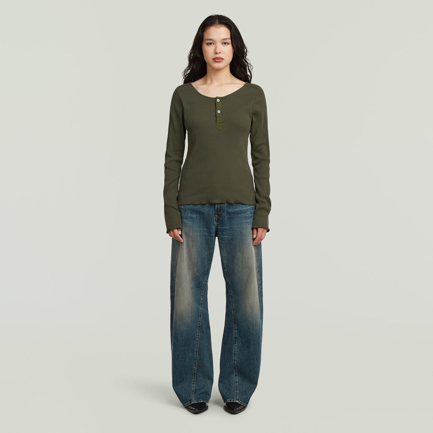 Mujer usando jeans Contor 3D wide fit en un ambiente neutral, mostrando su corte holgado y diseño moderno.