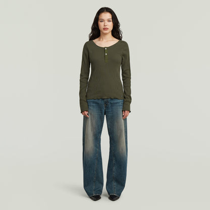 Mujer usando jeans Contor 3D wide fit en un ambiente neutral, mostrando su corte holgado y diseño moderno.