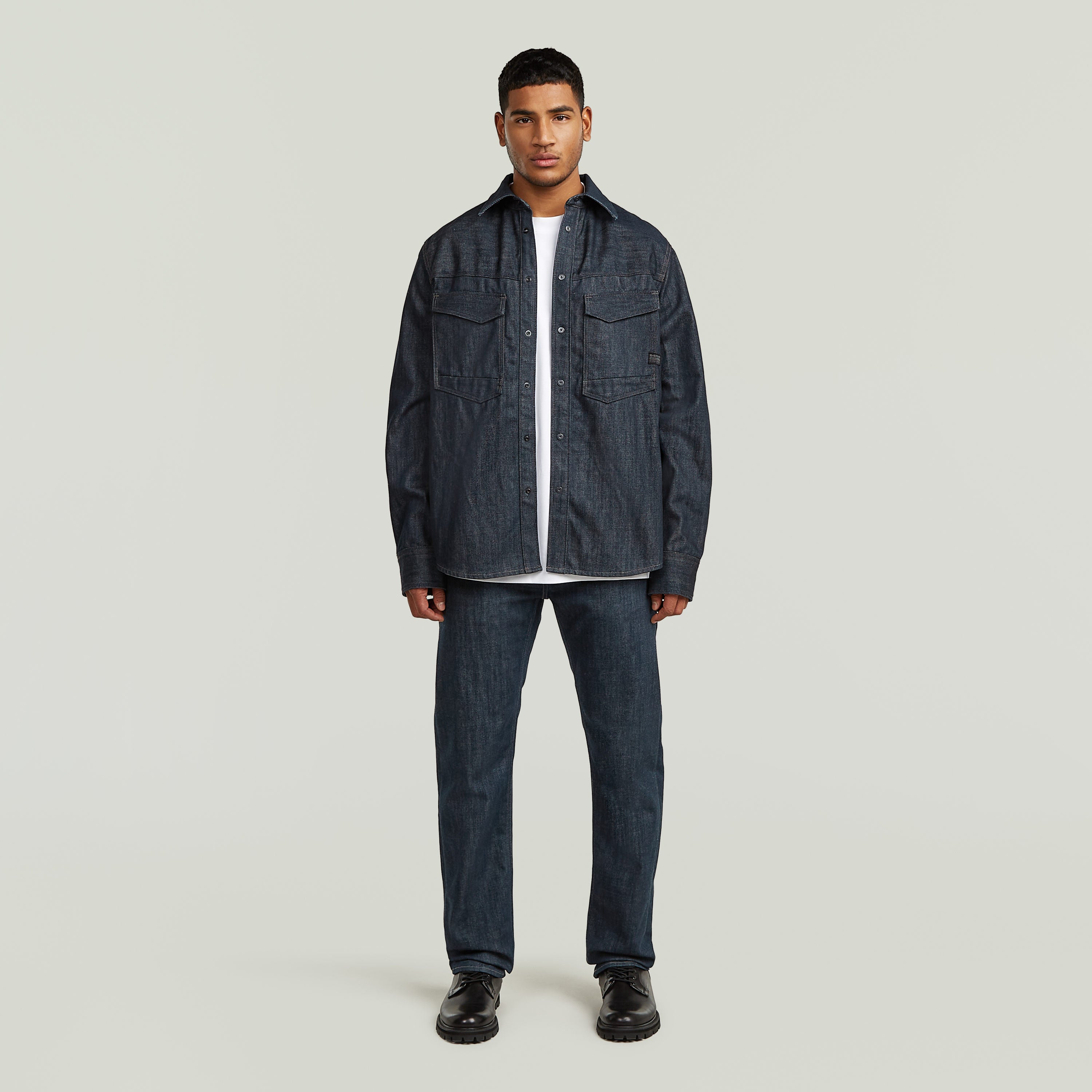 Modelo usando sobrecamisa regular Dakota en denim greencast, presentando un diseño elegante y práctico.