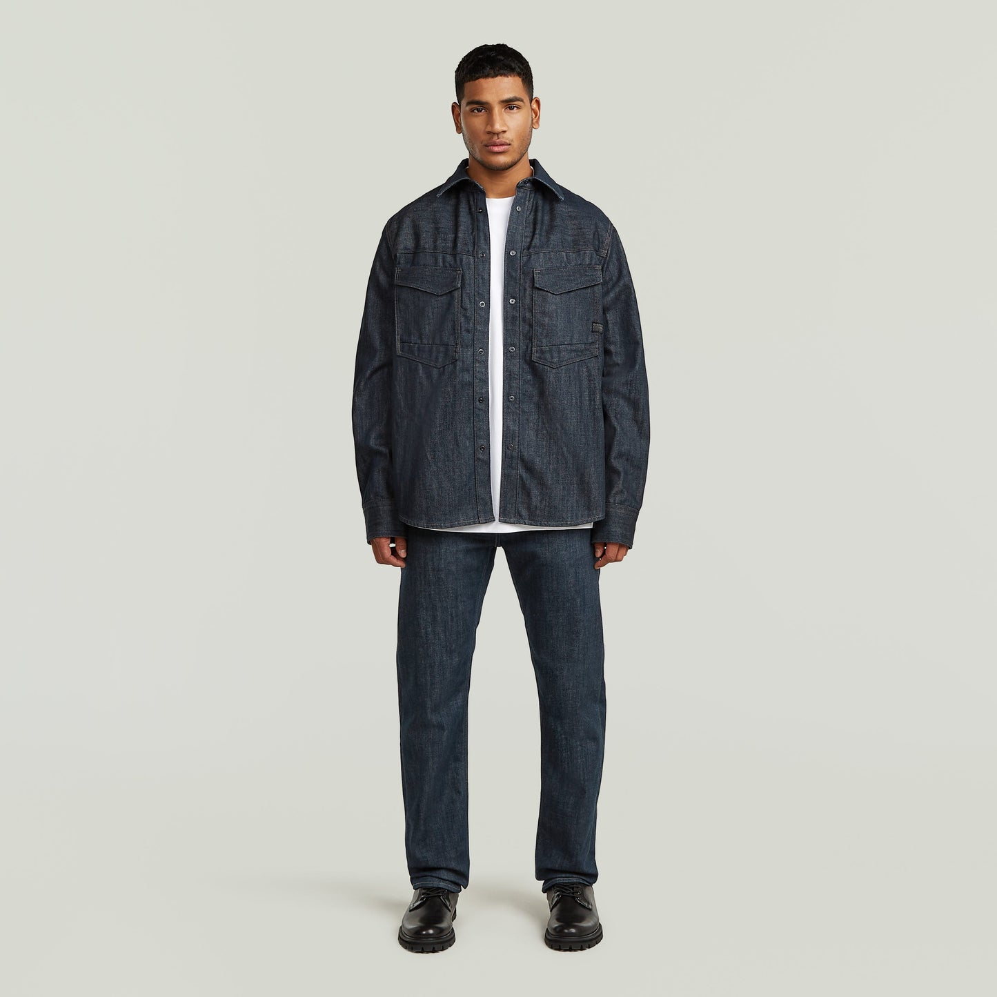 Modelo usando sobrecamisa regular Dakota en denim greencast, presentando un diseño elegante y práctico.