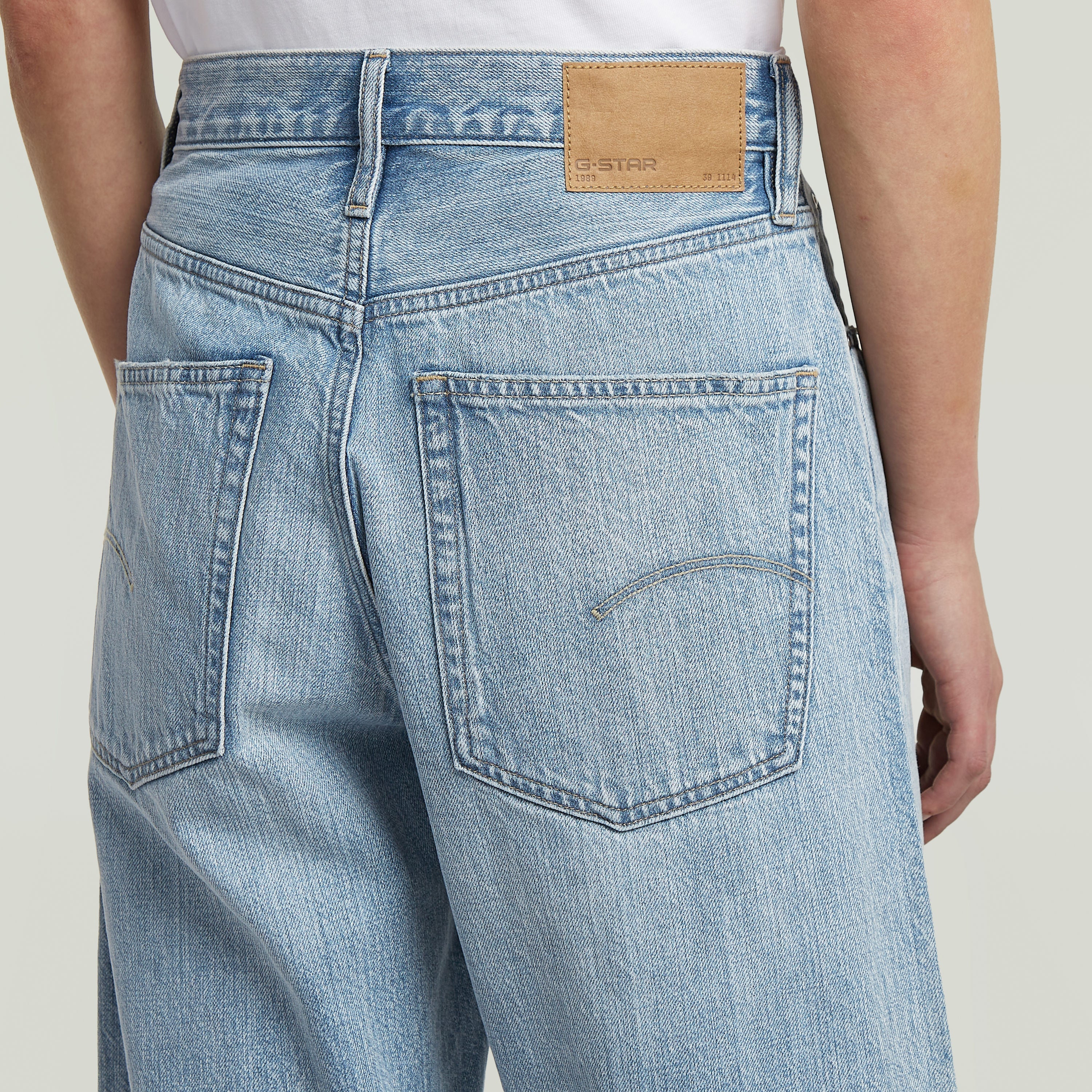Bermuda shorts clean edge back view showing pockets and G-Star label on a light blue denim fabric.