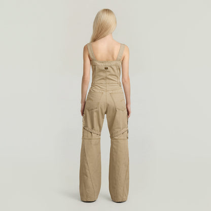 Mujer de espaldas vistiendo el elevated dungaree jumpsuit color beige con tiras racerback.