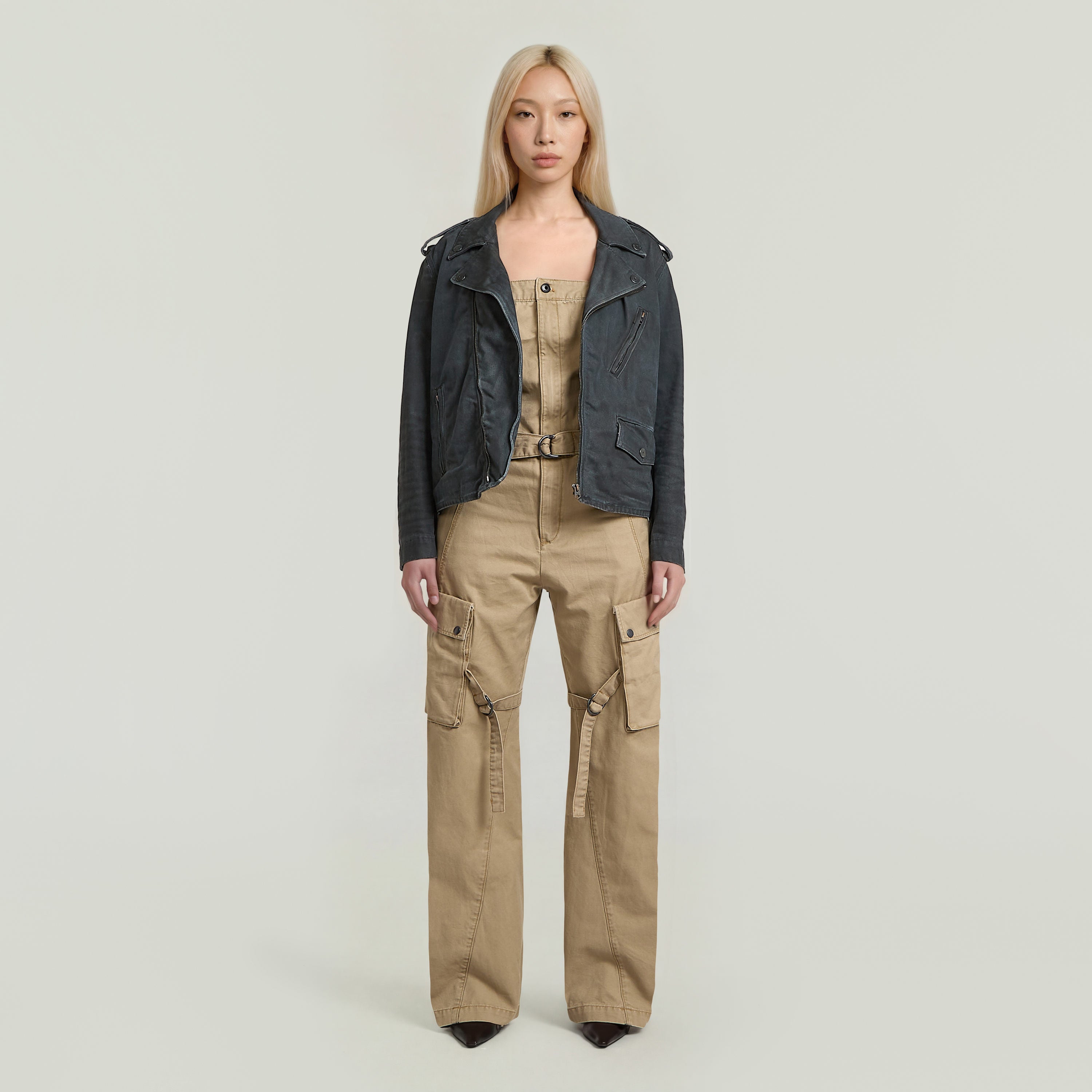 Model wearing a stylish Peto alto Elevated dungaree jumpsuit with a racerback design and a leather jacket.