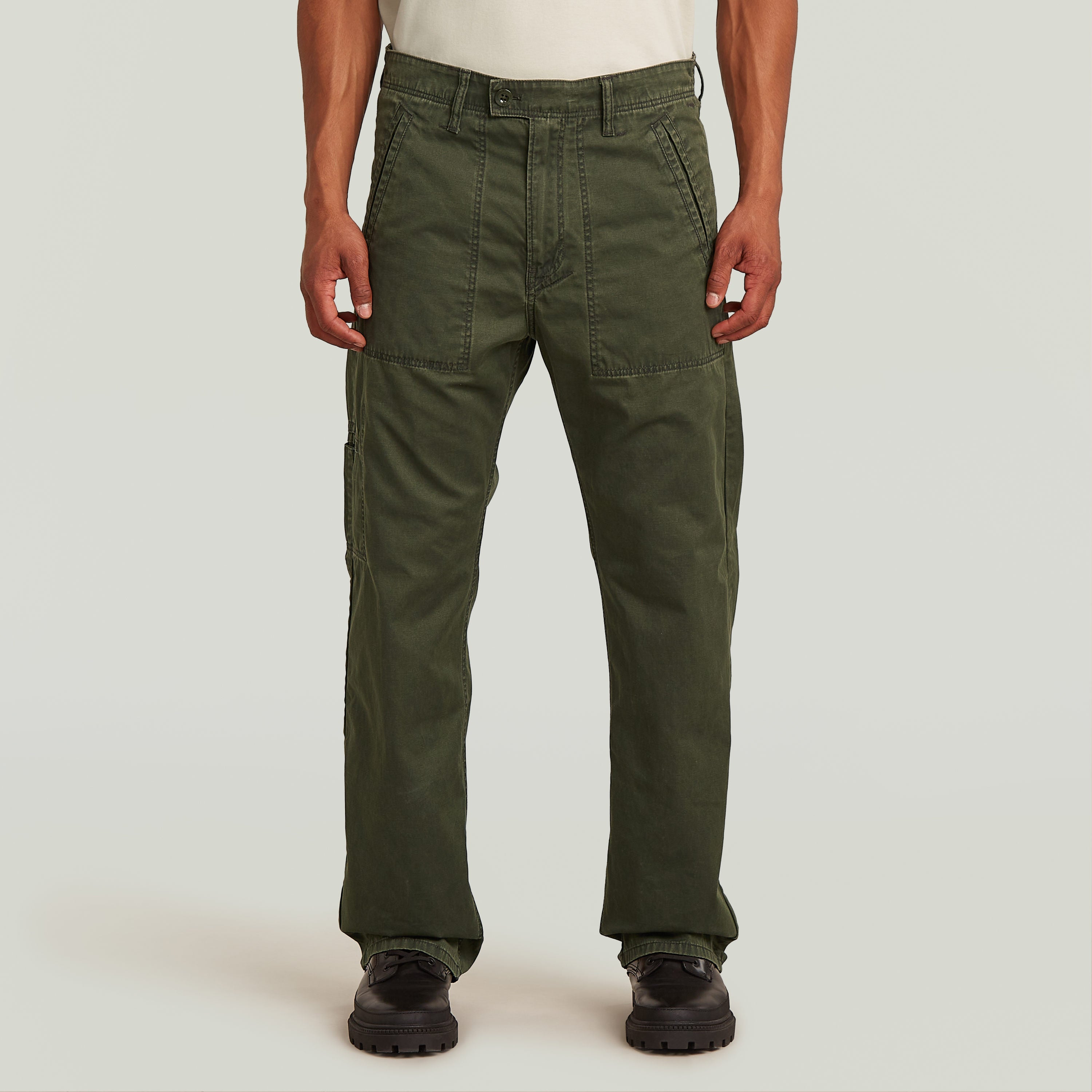Chico mostrando el Chino Reversible Relaxed Straight de color verde oscuro, con diseño de perneras rectas y tela resistente.