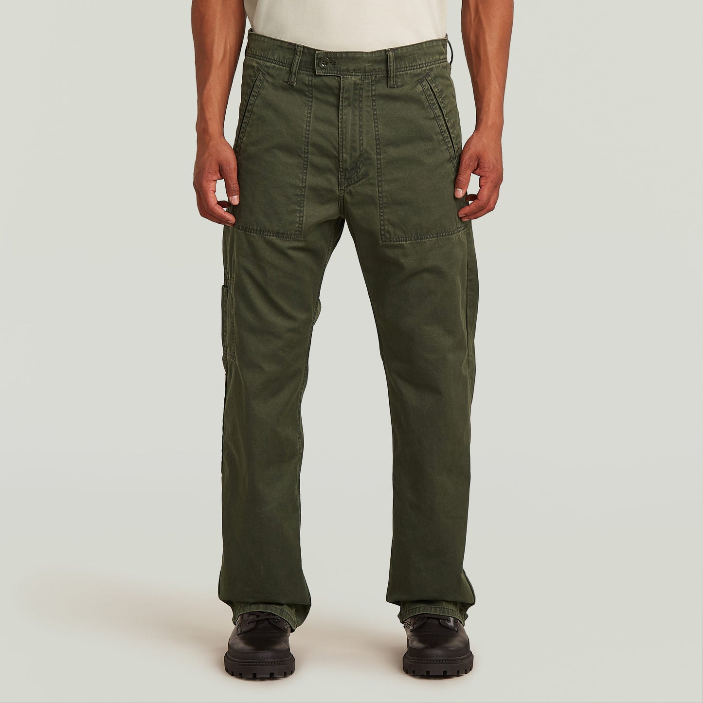 Chico mostrando el Chino Reversible Relaxed Straight de color verde oscuro, con diseño de perneras rectas y tela resistente.