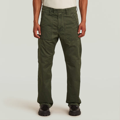 Chico mostrando el Chino Reversible Relaxed Straight de color verde oscuro, con diseño de perneras rectas y tela resistente.