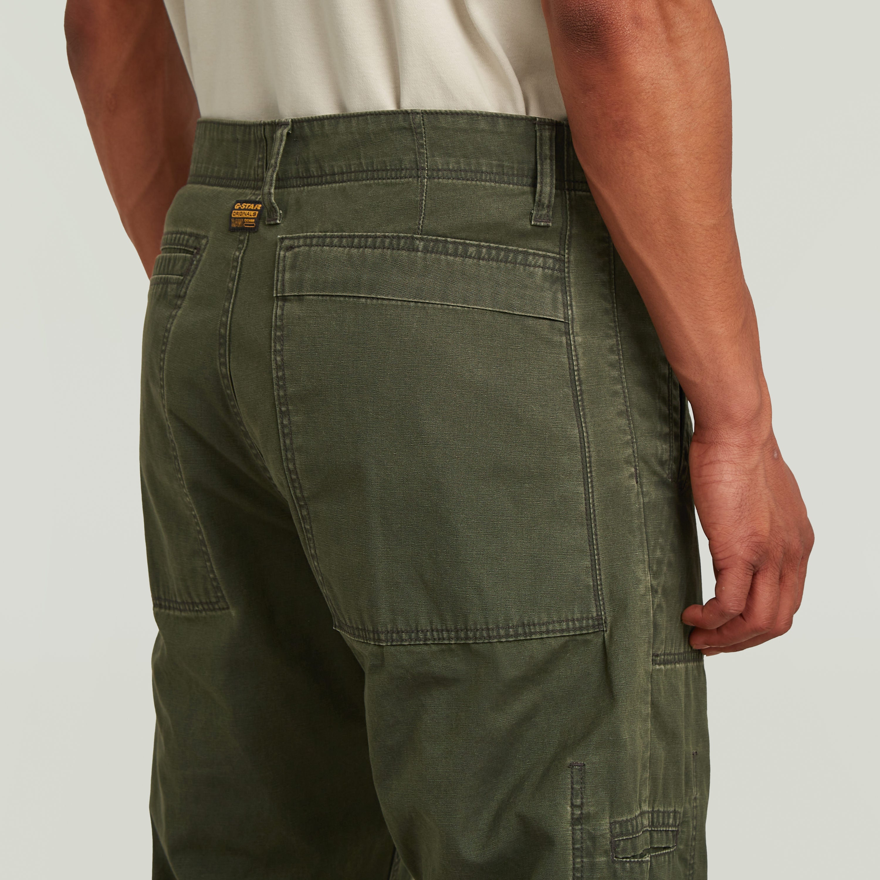 Reversible relaxed straight chinos in green, showcasing back pocket and waistband design.