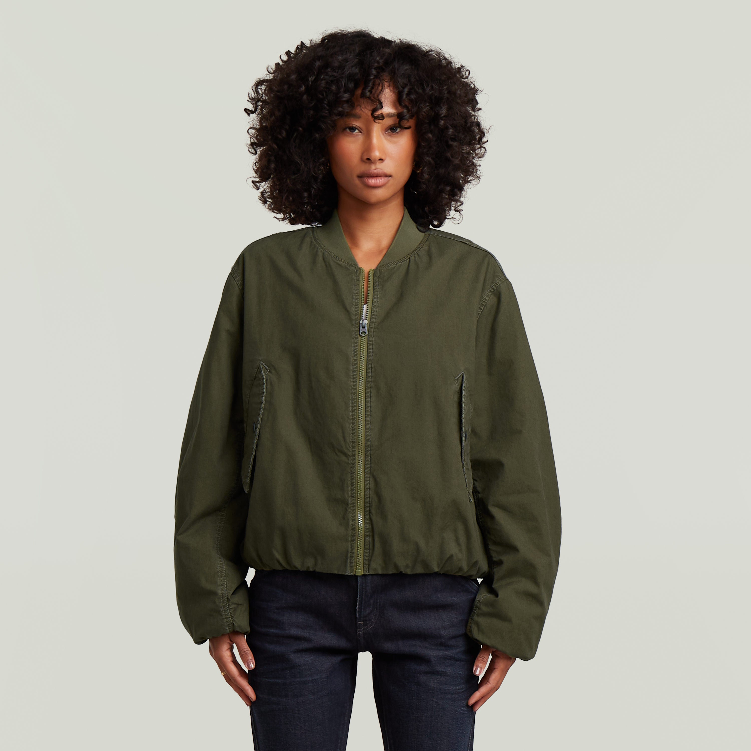 Modelo vistiendo una cazadora de aviador padded bomber jacket color verde con diseño acolchado.
