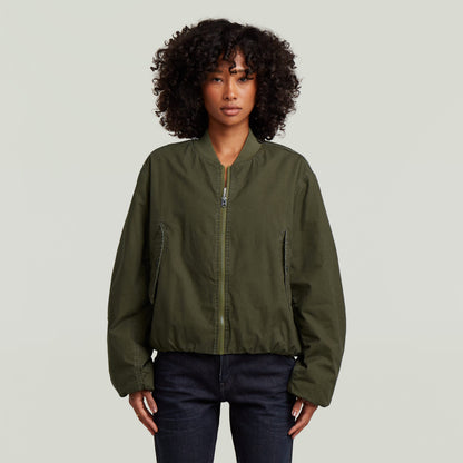 Modelo vistiendo una cazadora de aviador padded bomber jacket color verde con diseño acolchado.
