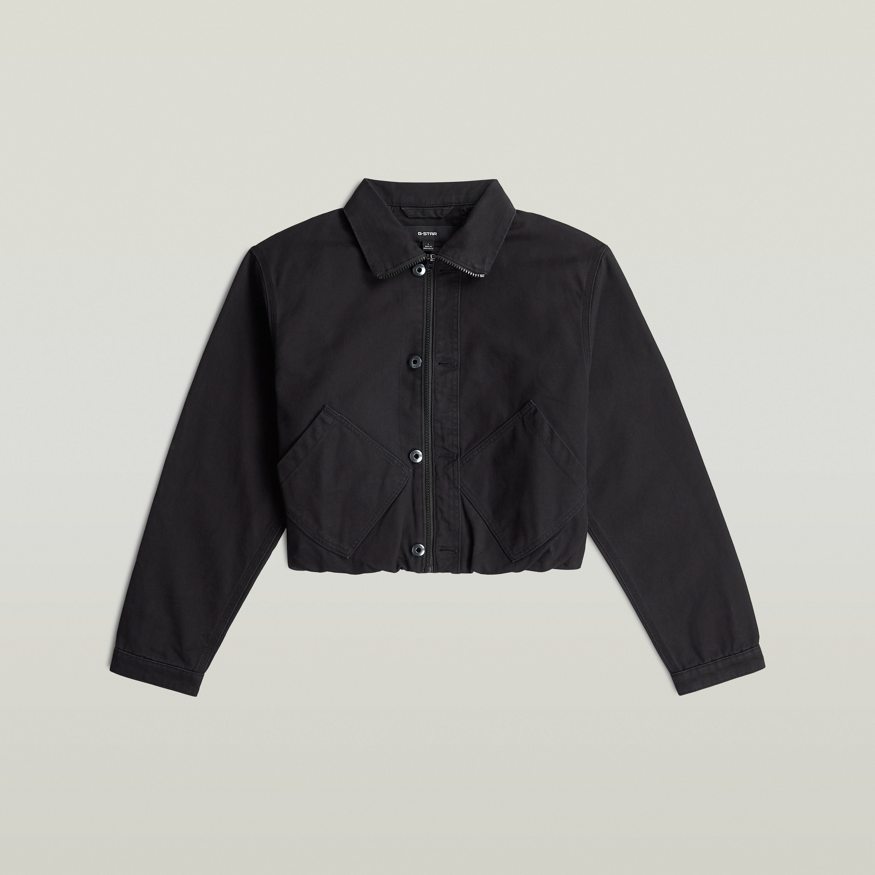 Cazadora cropped barn de color negro con cuello de camisa y cierre de botón y cremallera.
