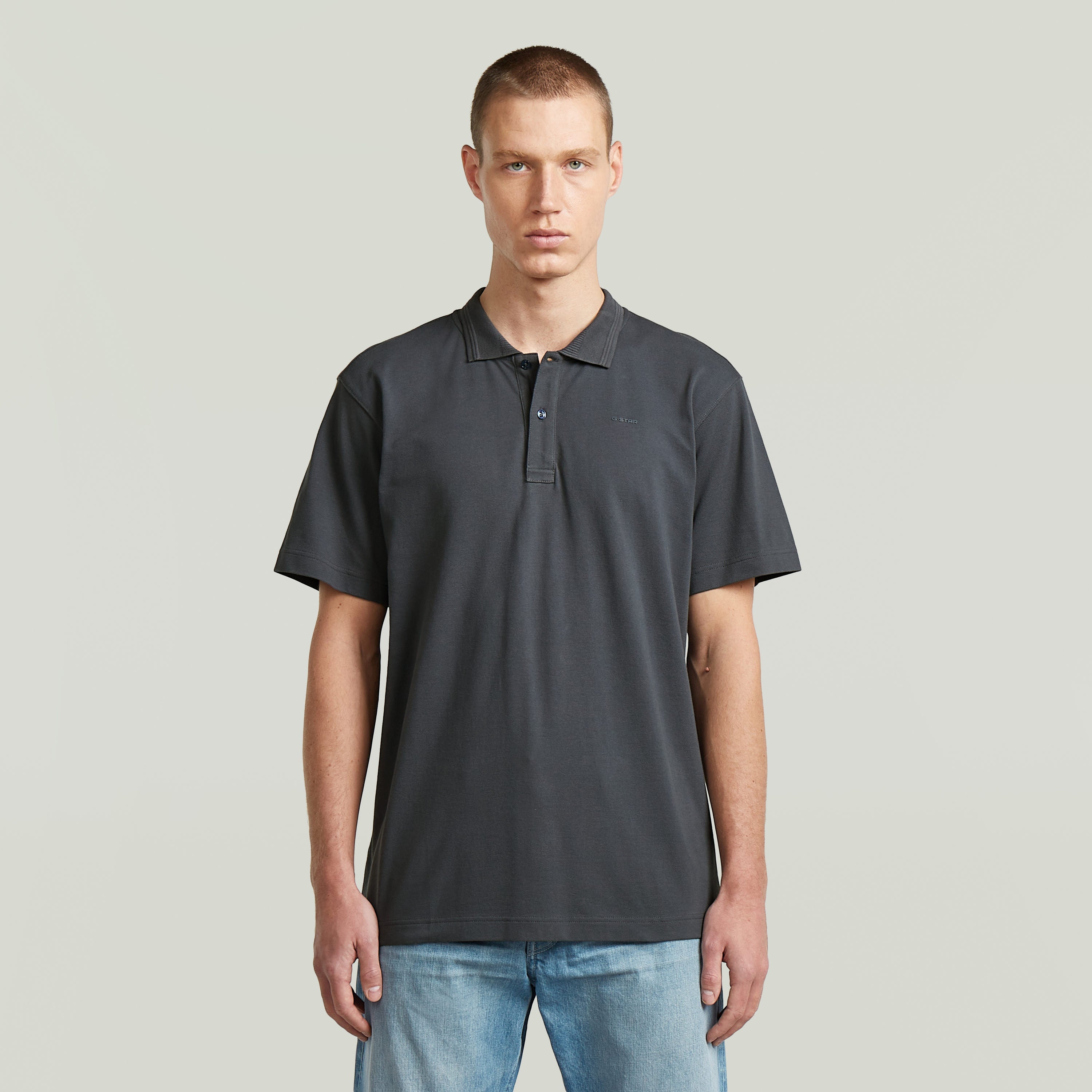 Model wearing the polo core regular shirt in gray, featuring a classic collar and button closure.