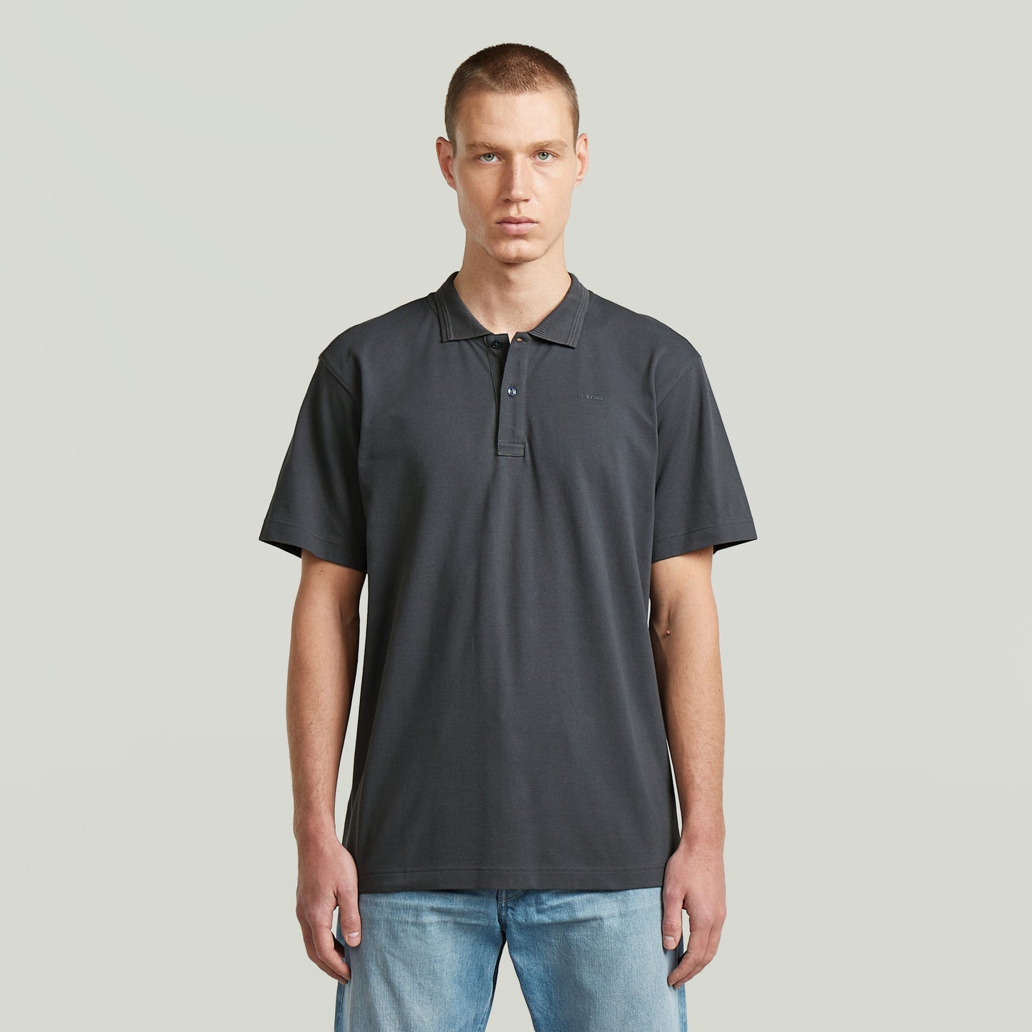 Model wearing the polo core regular shirt in gray, featuring a classic collar and button closure.