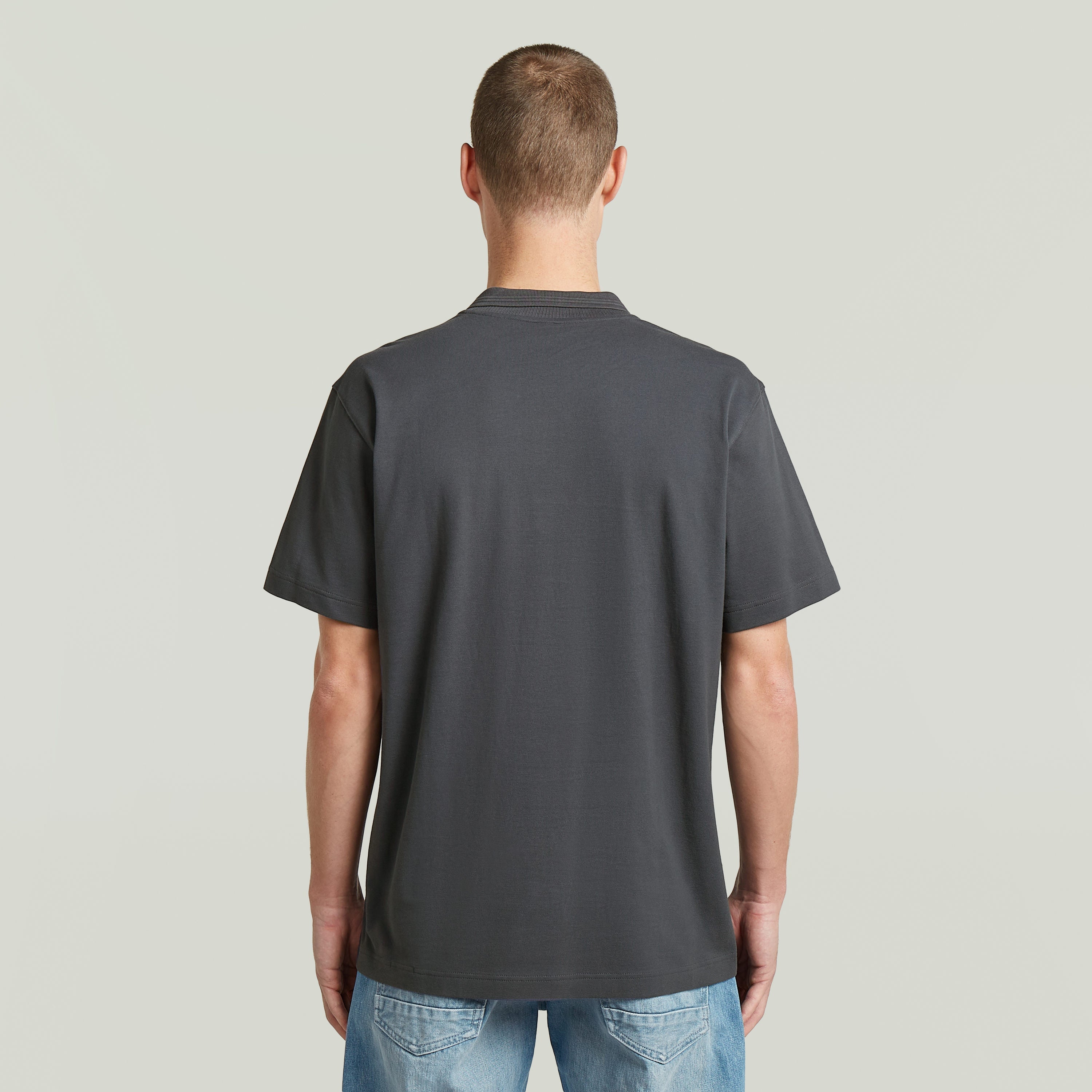 Vista trasera de la camisa polo core regular shirt en color gris, con mangas cortas y corte recto.