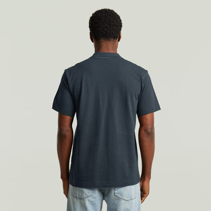 Hombre usando una eco-friendly polo shirt de color azul oscuro, vista trasera, diseño cómodo y elegante.