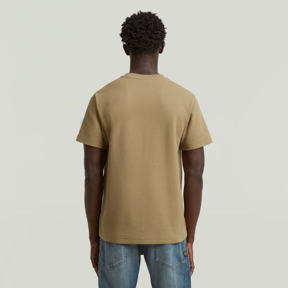 Back view of a man wearing a beige regular fit waffle t-shirt with a classic look.
