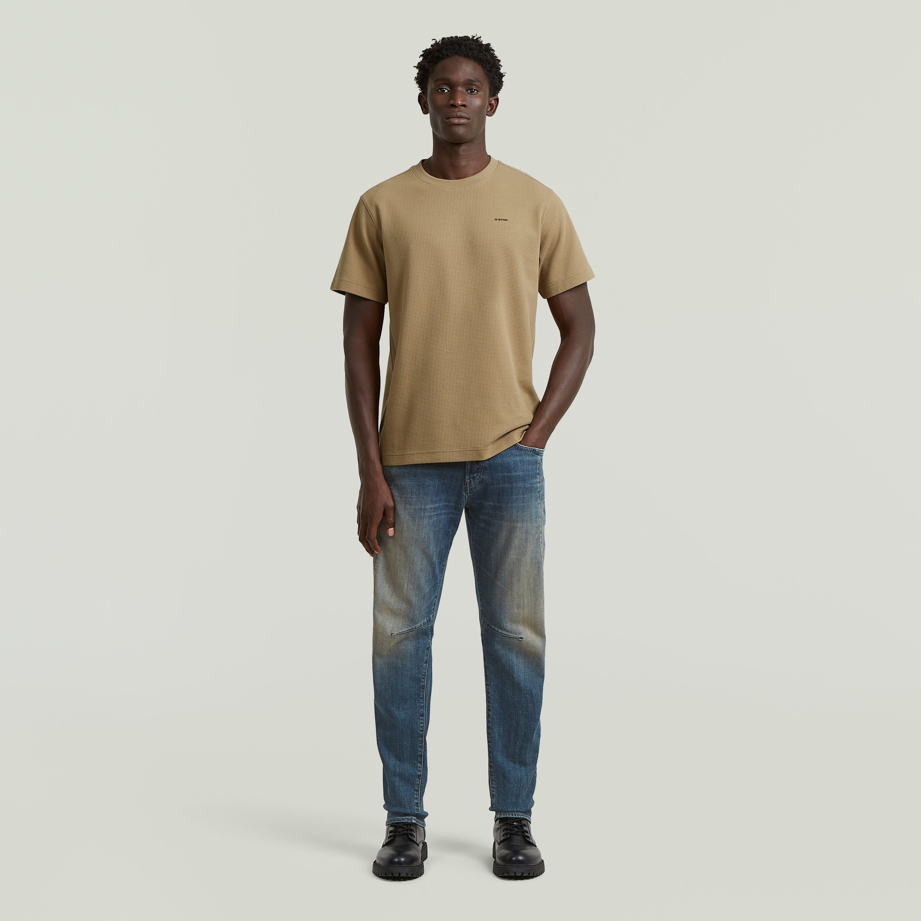 Model wearing a regular fit waffle t-shirt in beige with jeans on a neutral background.