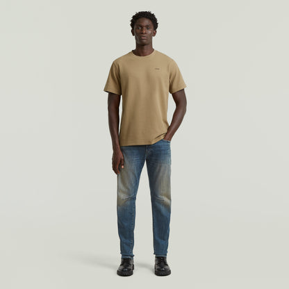 Model wearing a regular fit waffle t-shirt in beige with jeans on a neutral background.