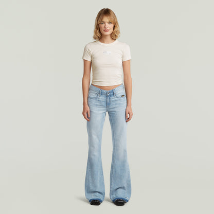 Mujer luciendo jeans Stevey 3D Flare, estilo bootcut en color azul intermedio, 100% algodón.