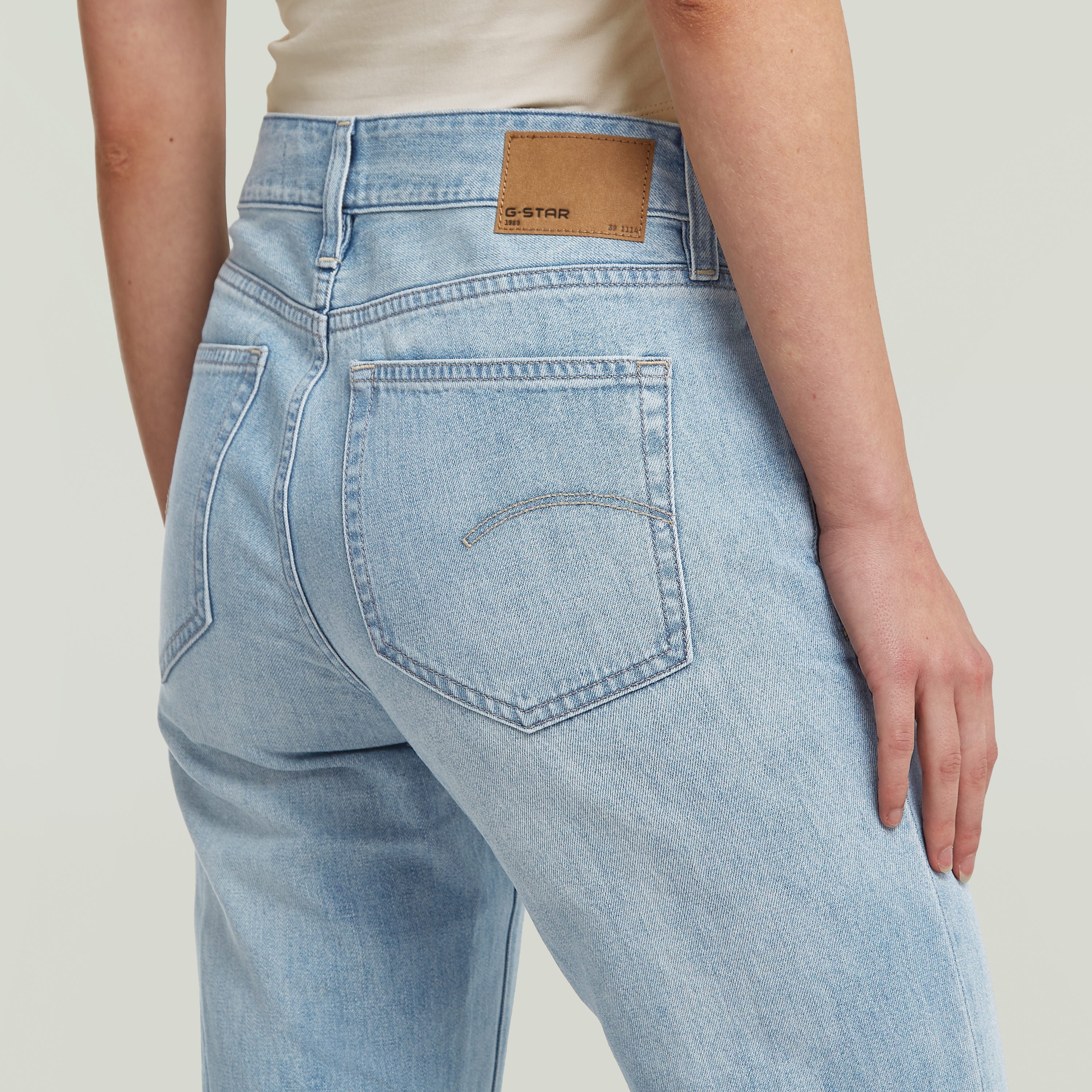 Mujer usando jeans Stevey 3D Flare, mostrando el diseño bootcut y colores intermedios en un fondo claro.