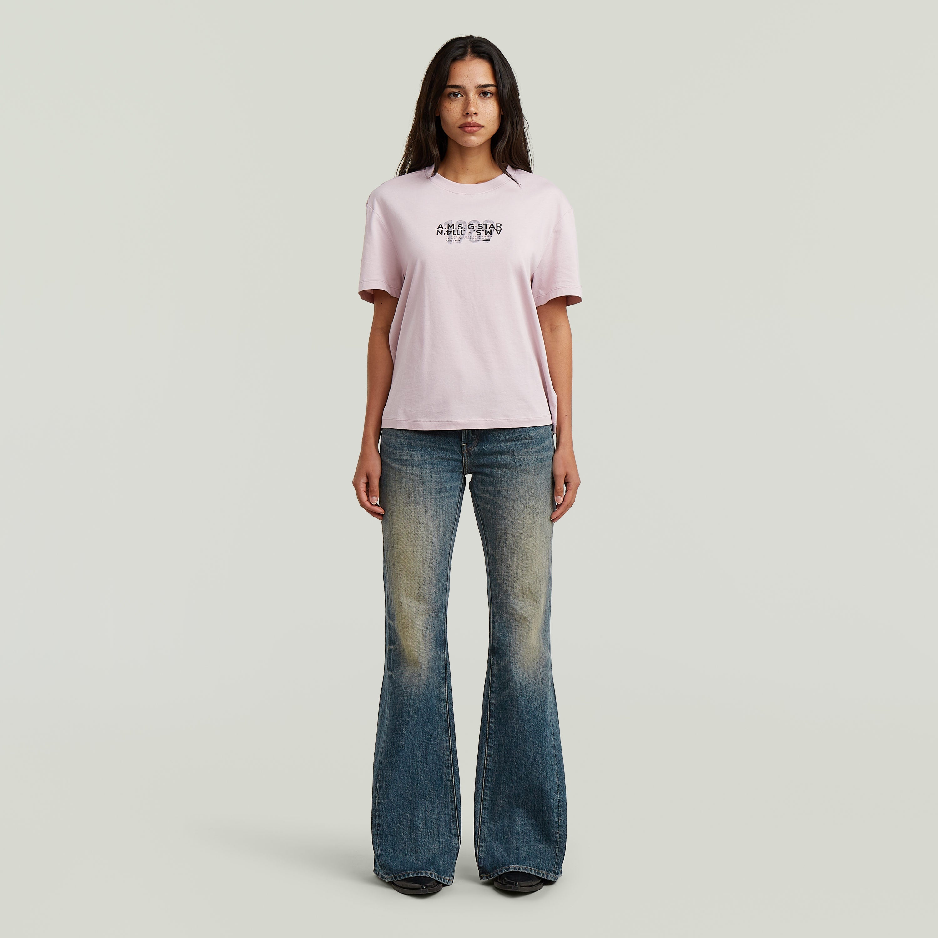 Mujer luciendo jeans Stevey 3D Flare con diseño bootcut, combinados con camiseta de manga corta.