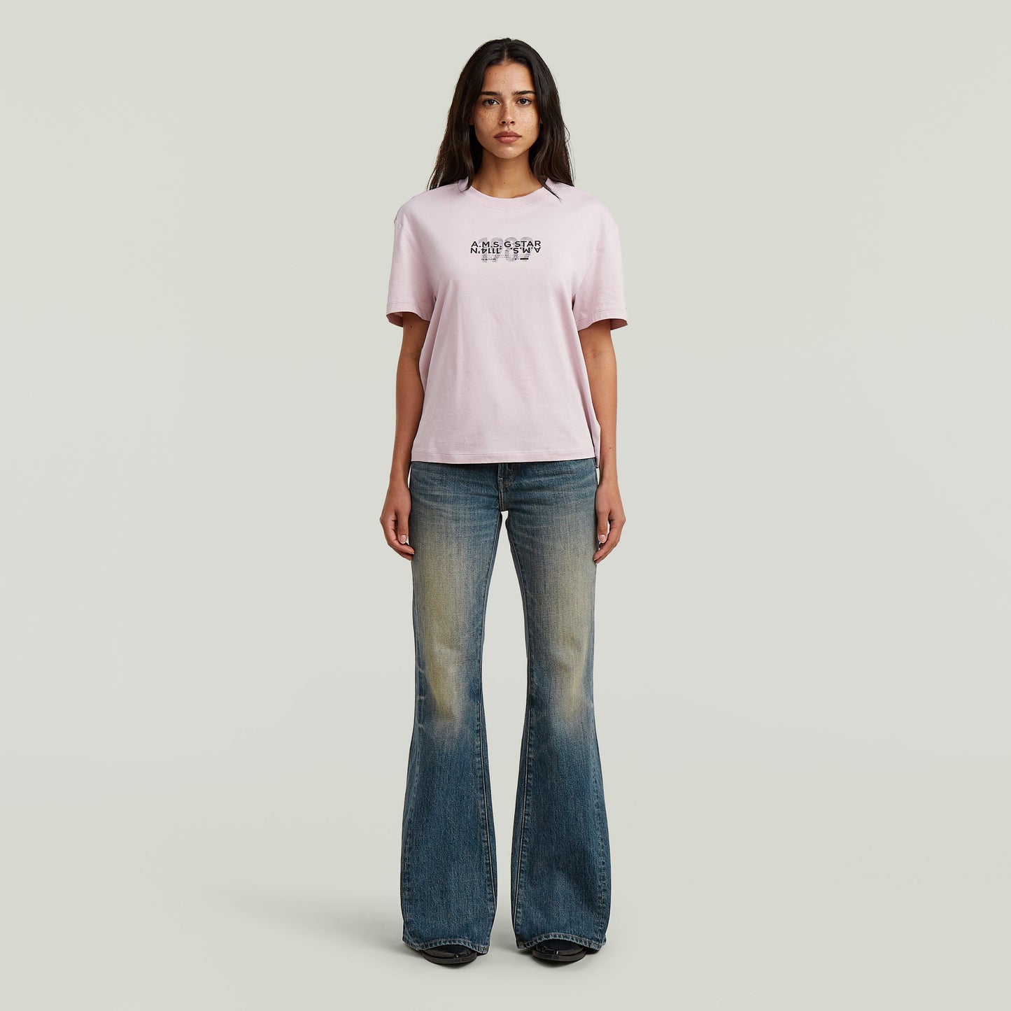 Mujer luciendo jeans Stevey 3D Flare con diseño bootcut, combinados con camiseta de manga corta.