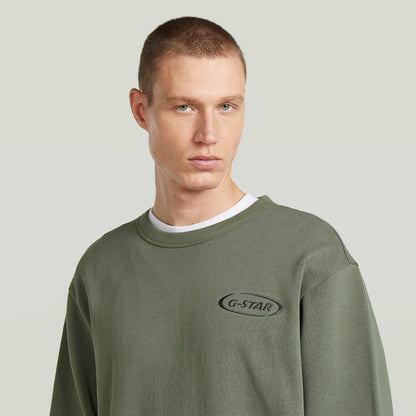 Sudadera con logotipo de los 90 en color verde, con corte regular y cuello redondo, 100% algodón ecológico.