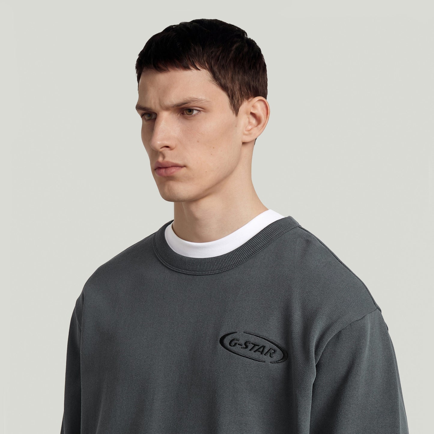 Sudadera con logotipo de los 90 en color gris, con cuello redondo y diseño gráfico en el pecho.