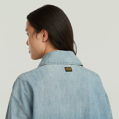 Mujer usando chaqueta parachute oversized con parche de G-STAR en la parte trasera, color azul claro.