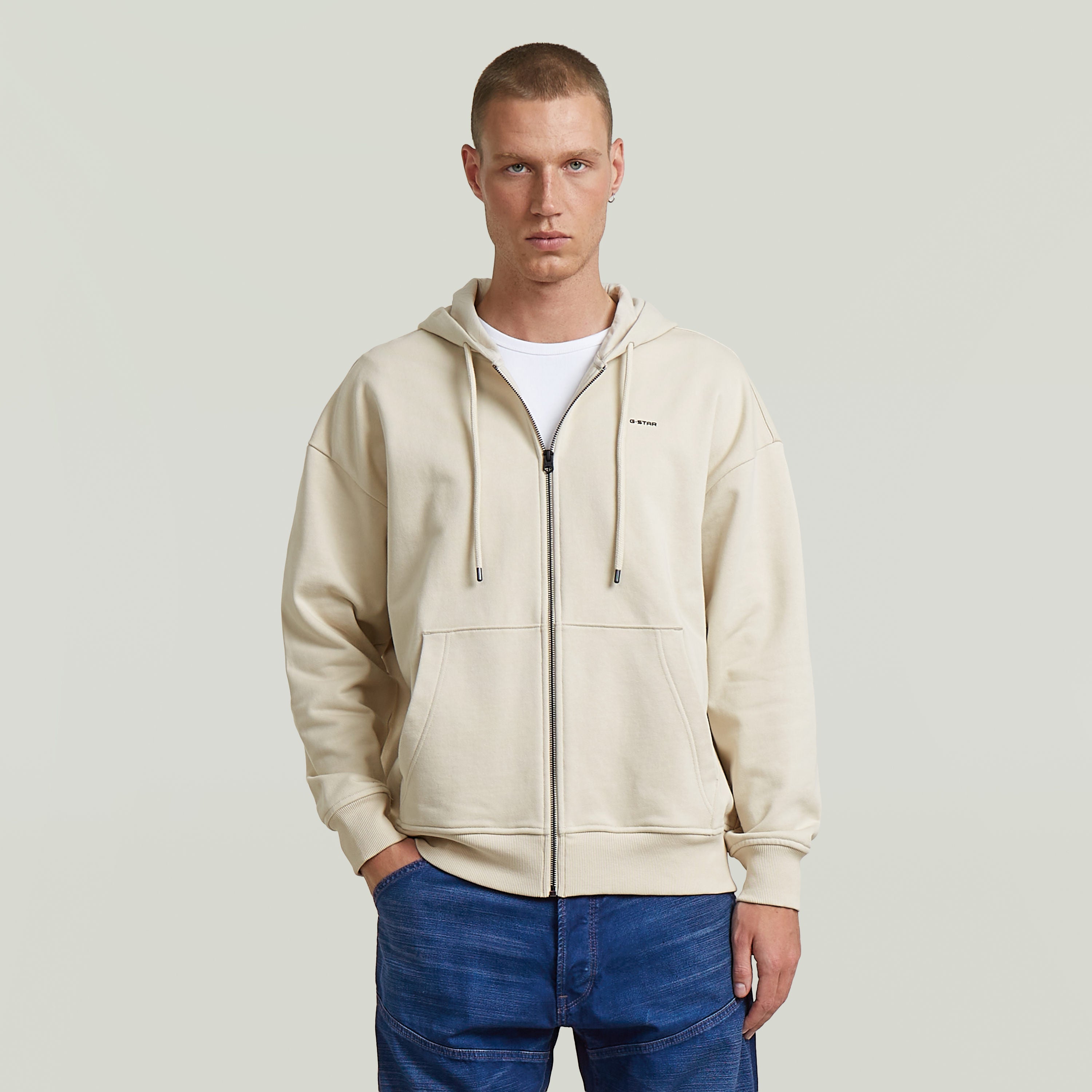 Sudadera Back Graphic Loose con Capucha y Cremallera El Back Graphic Loose Hooded Zip Sweater tiene fit holgado con capucha y cierre de cremallera, para un estilo relajado y casual.