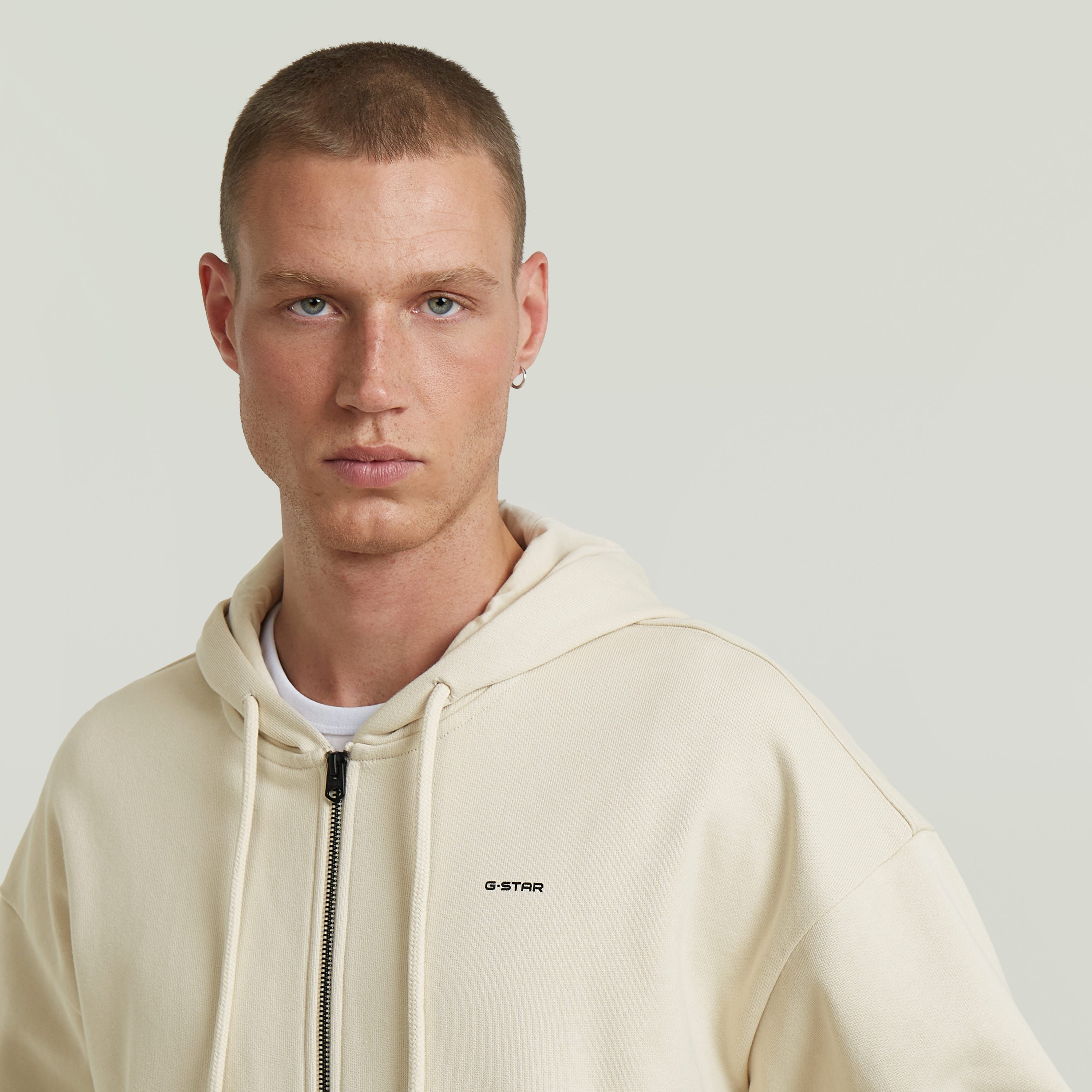 Sudadera Back Graphic Loose con Capucha y Cremallera El Back Graphic Loose Hooded Zip Sweater tiene fit holgado con capucha y cierre de cremallera, para un estilo relajado y casual.