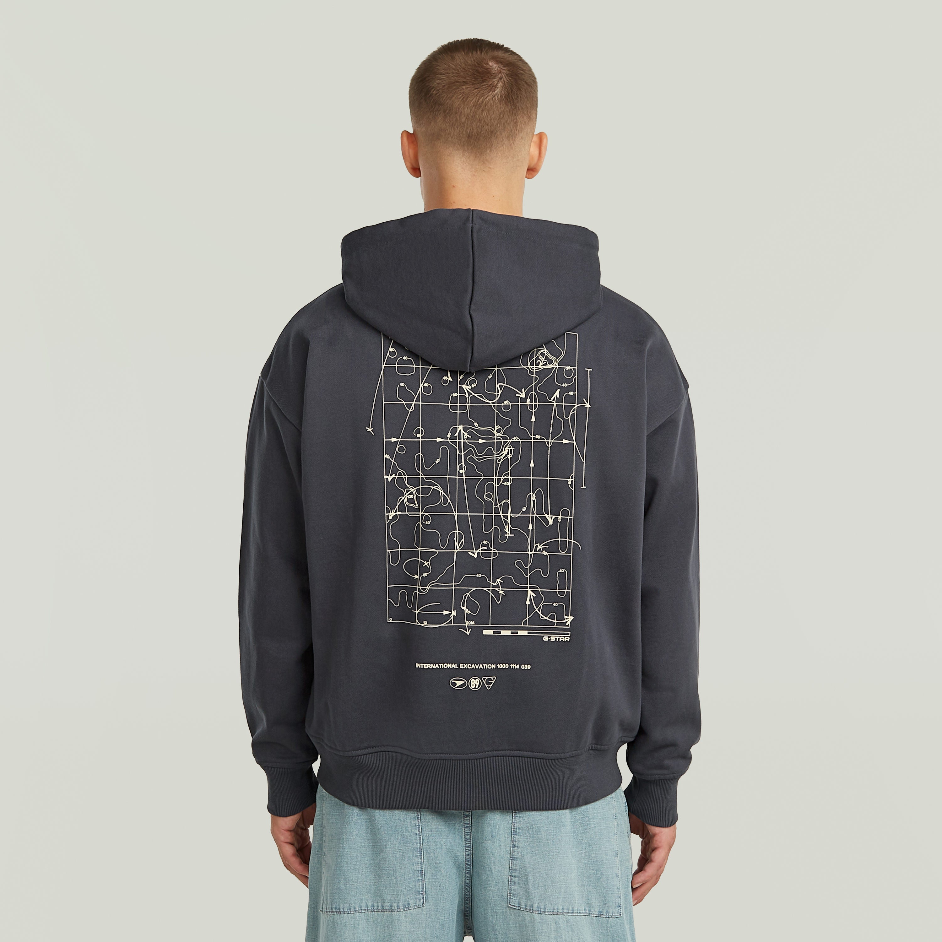 Sudadera Back Graphic Loose con Capucha y Cremallera El Back Graphic Loose Hooded Zip Sweater tiene fit holgado con cierre de cremallera y capucha, para un estilo casual y cómodo.