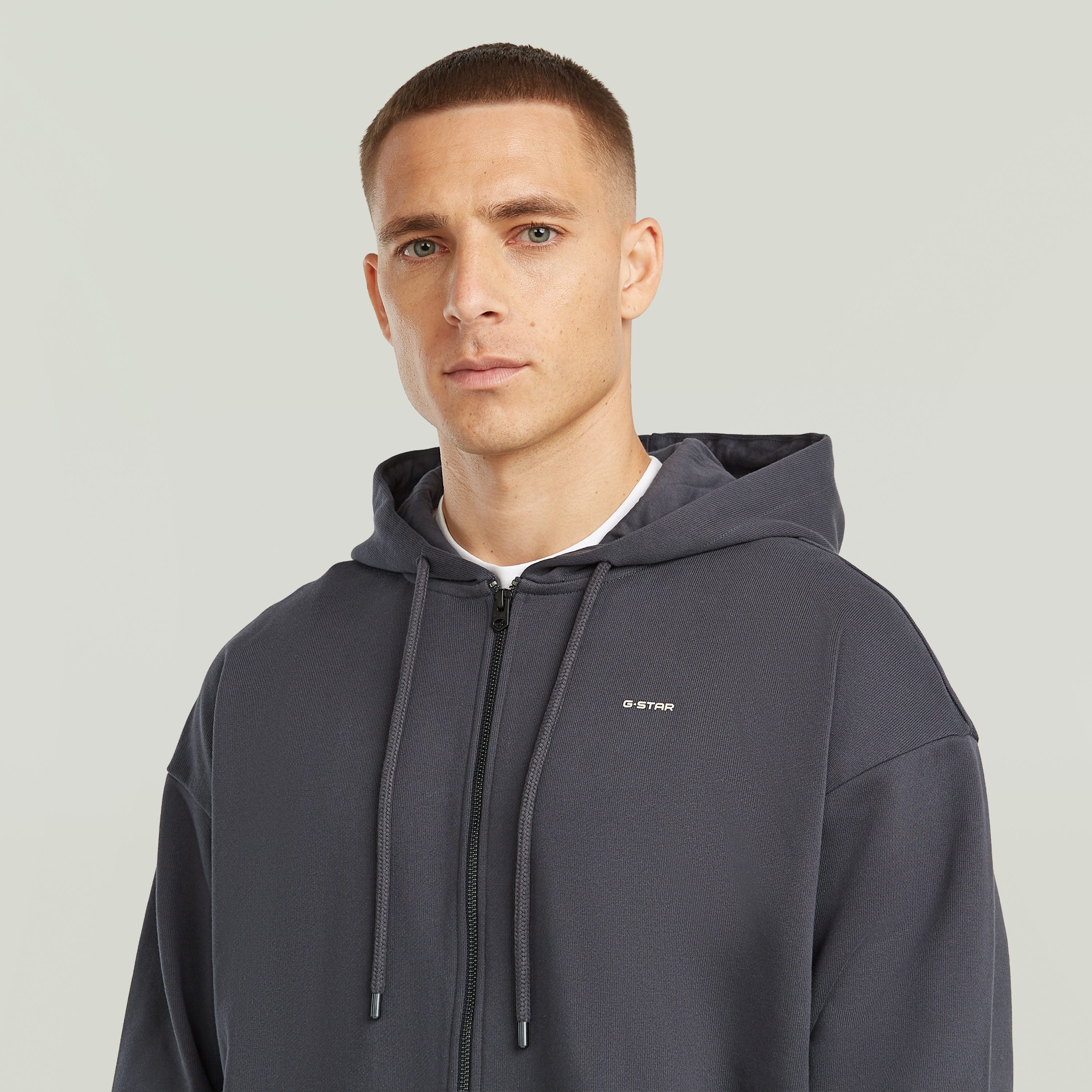 Sudadera Back Graphic Loose con Capucha y Cremallera El Back Graphic Loose Hooded Zip Sweater tiene fit holgado con cierre de cremallera y capucha, para un estilo casual y cómodo.