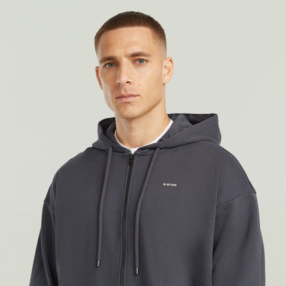 Sudadera Back Graphic Loose con Capucha y Cremallera El Back Graphic Loose Hooded Zip Sweater tiene fit holgado con cierre de cremallera y capucha, para un estilo casual y cómodo.